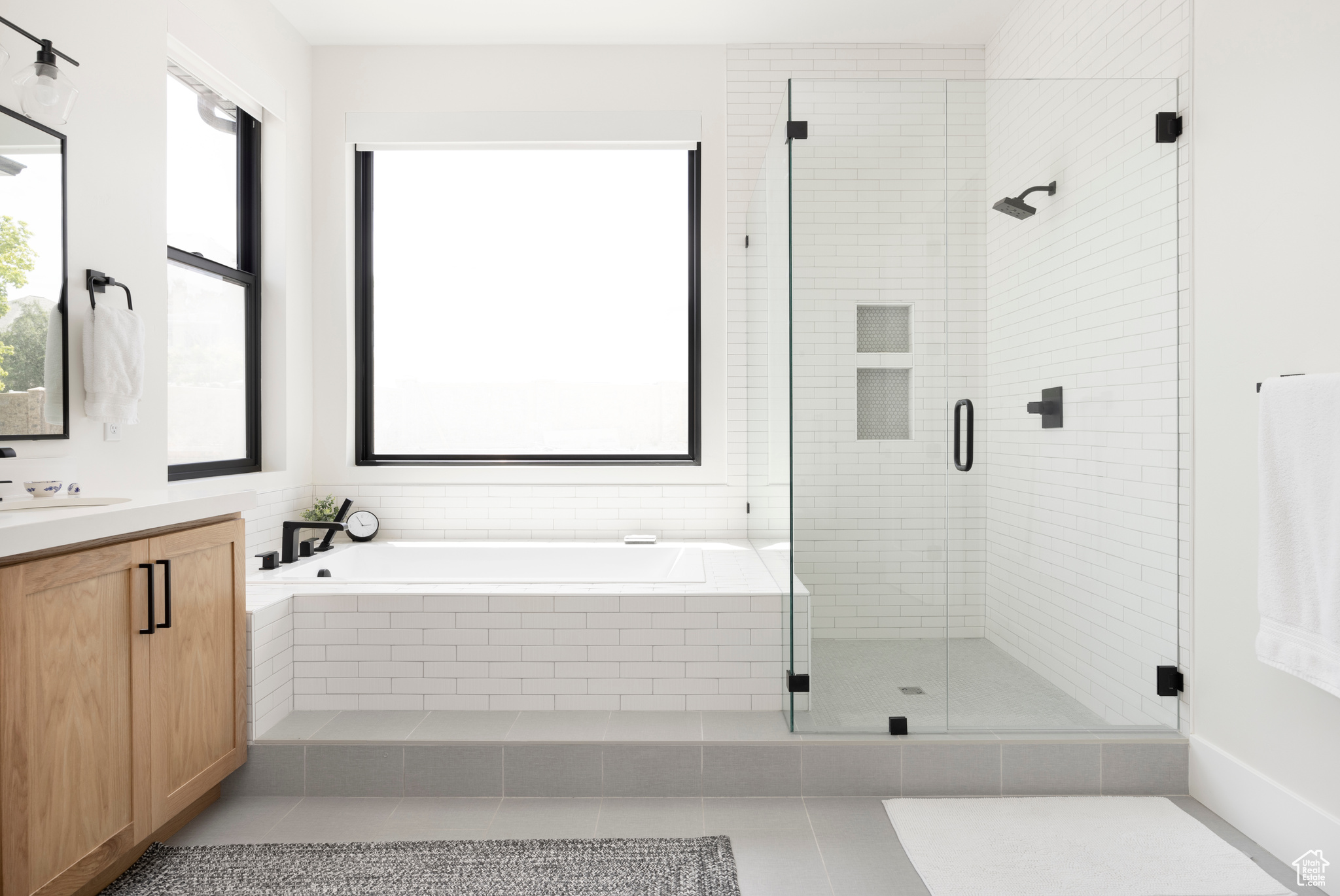 Bathroom featuring vanity, plenty of natural light, plus walk in shower, and tile patterned flooring