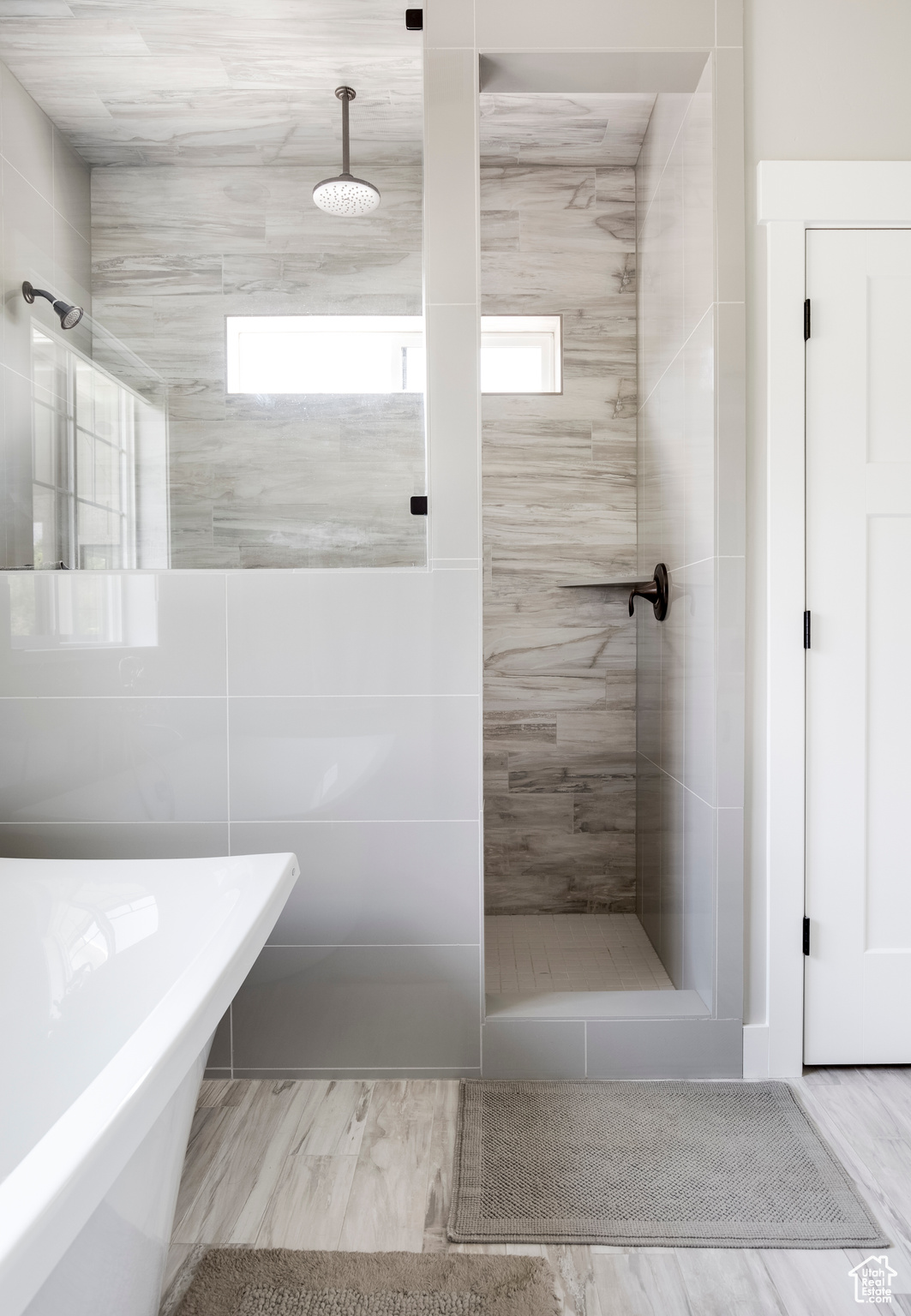 Bathroom with hardwood / wood-style floors, a wealth of natural light, and independent shower and bath