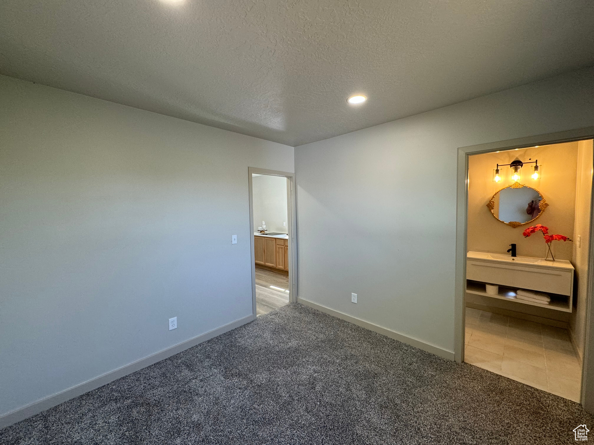 Unfurnished bedroom with a textured ceiling and carpet flooring