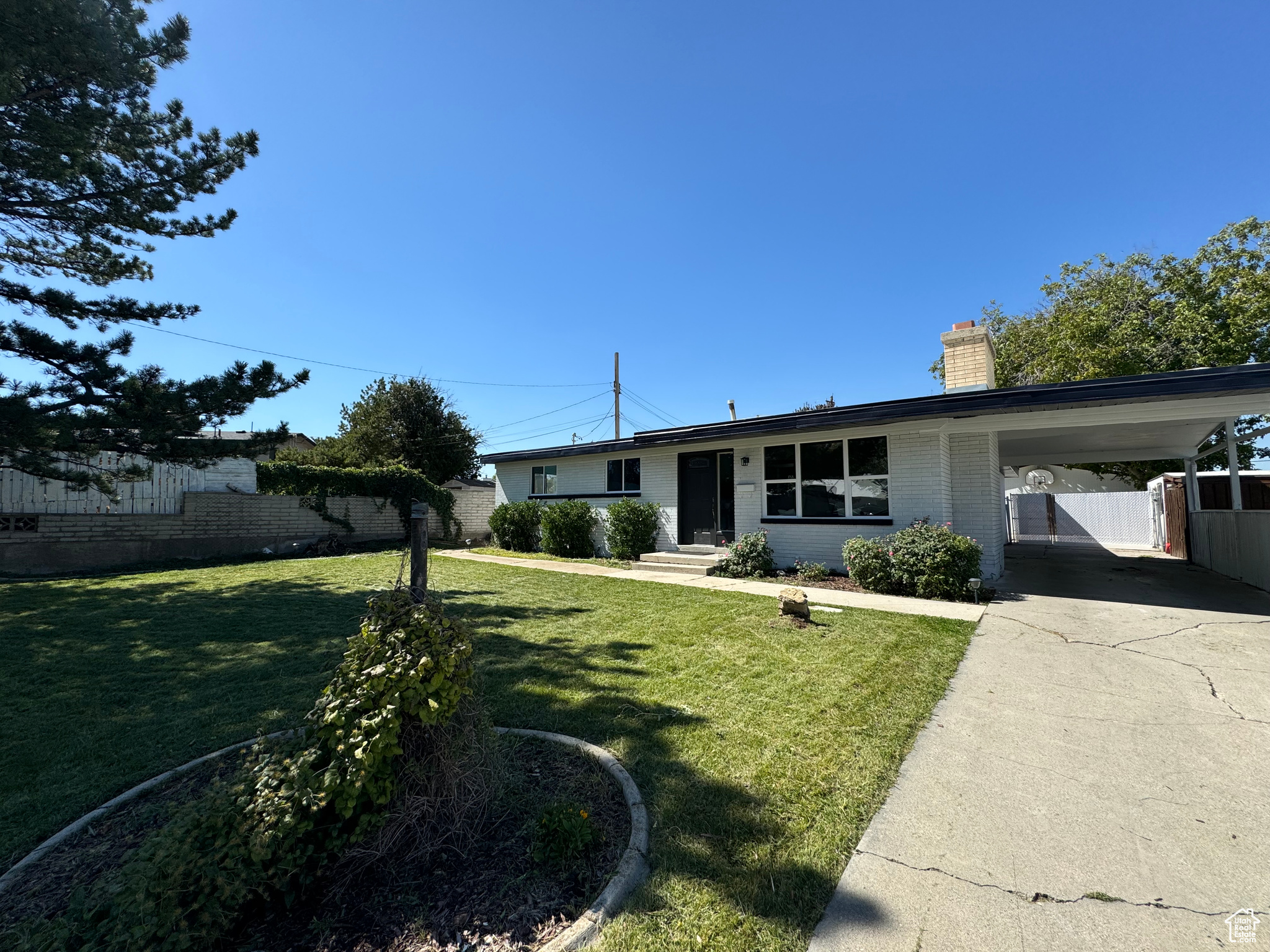 View of front facade with a front lawn and a carport