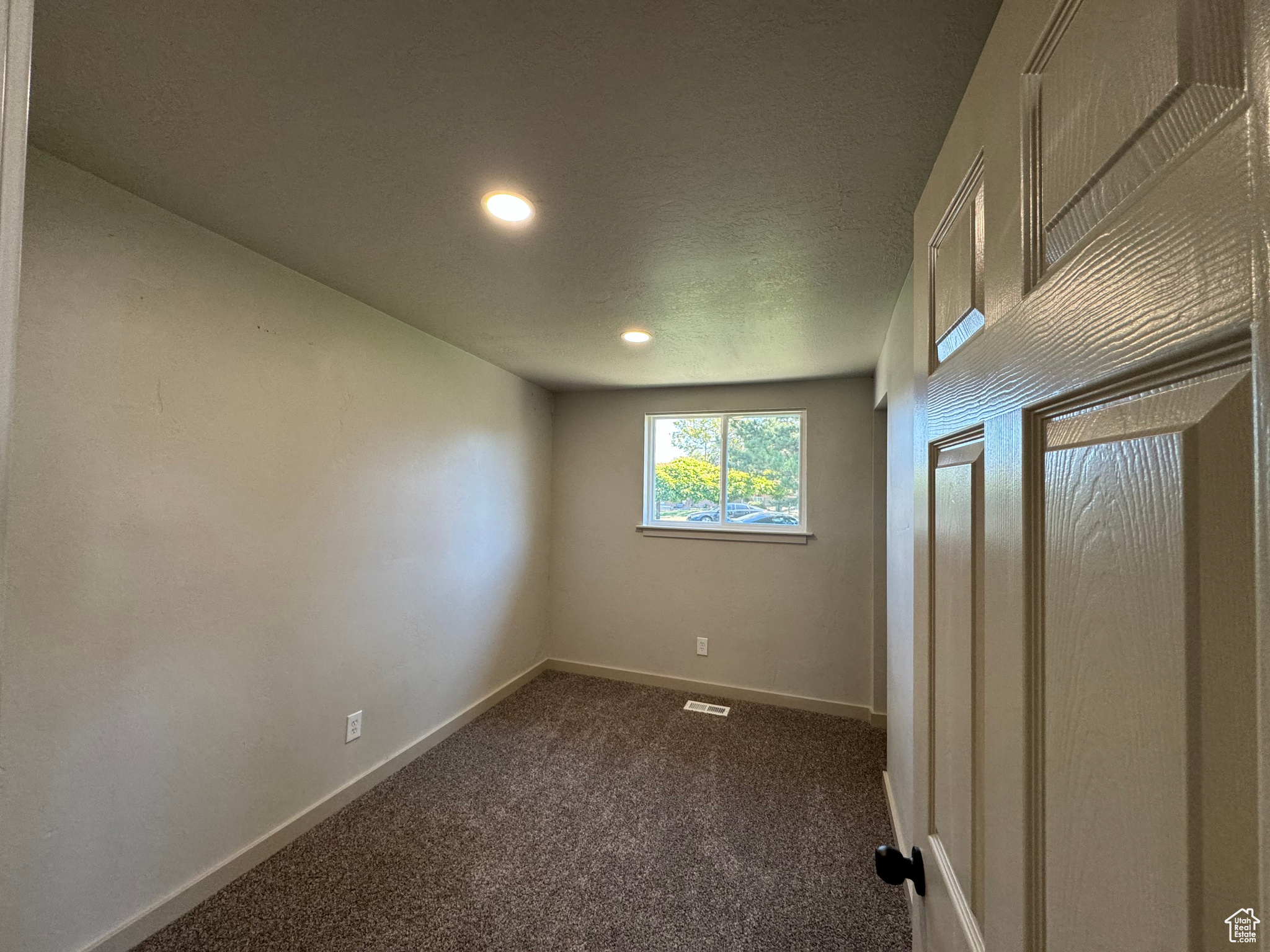 Carpeted spare room featuring a textured ceiling