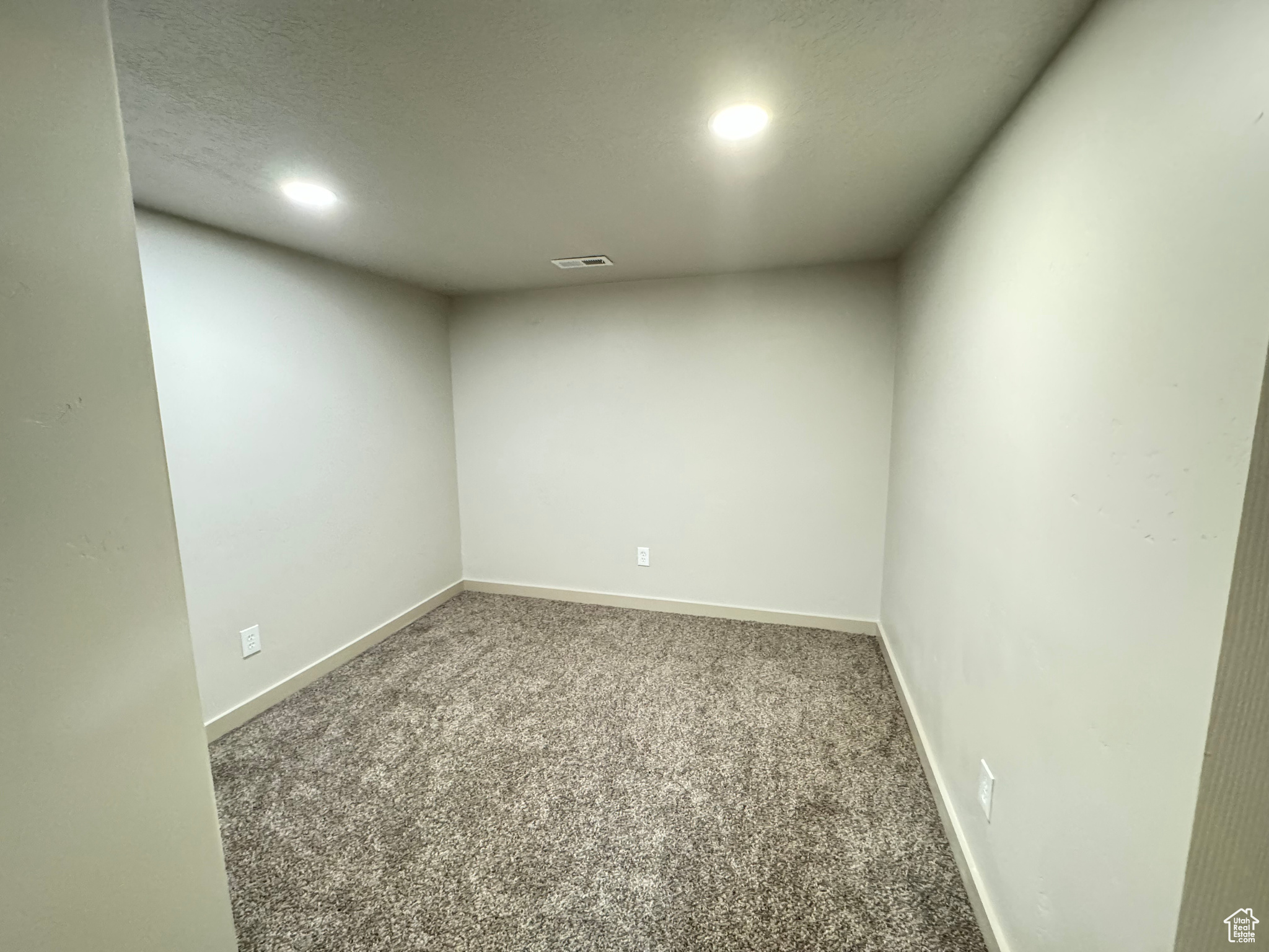 Carpeted spare room featuring a textured ceiling