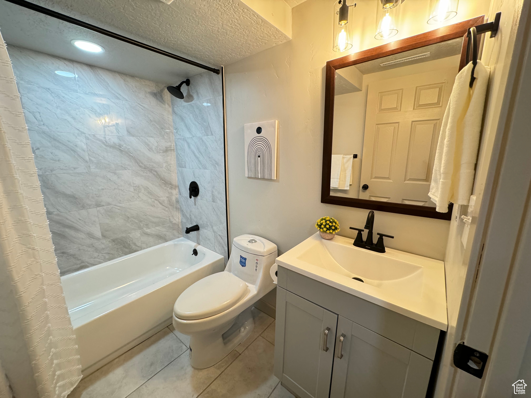 Full bathroom with toilet, tile patterned floors, vanity, a textured ceiling, and shower / tub combo with curtain