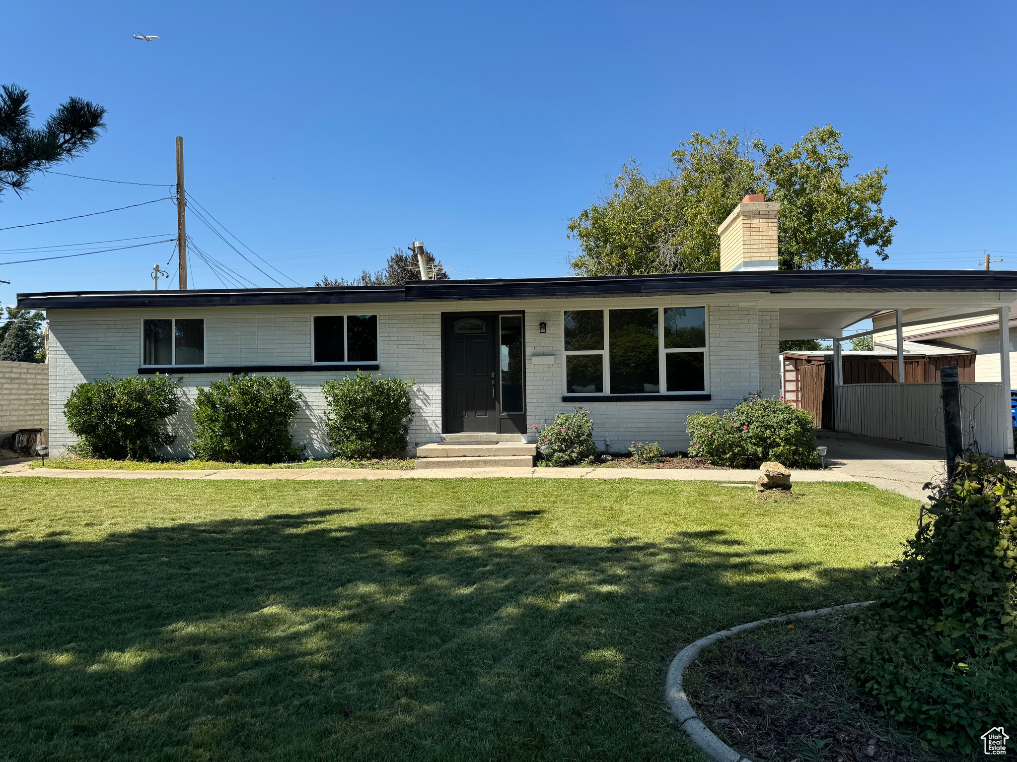 View of front of home featuring a carport and a front yard