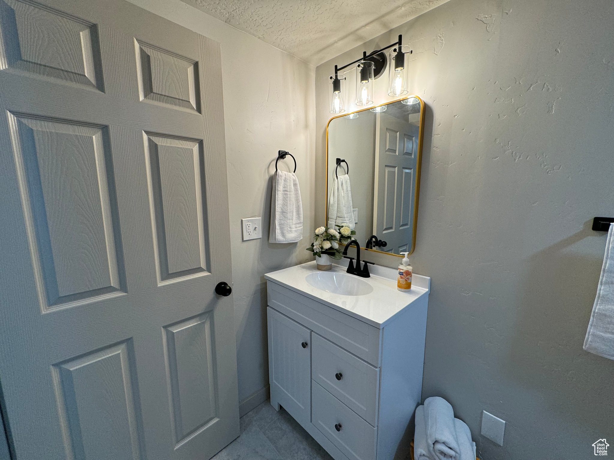 Bathroom with vanity and a textured ceiling