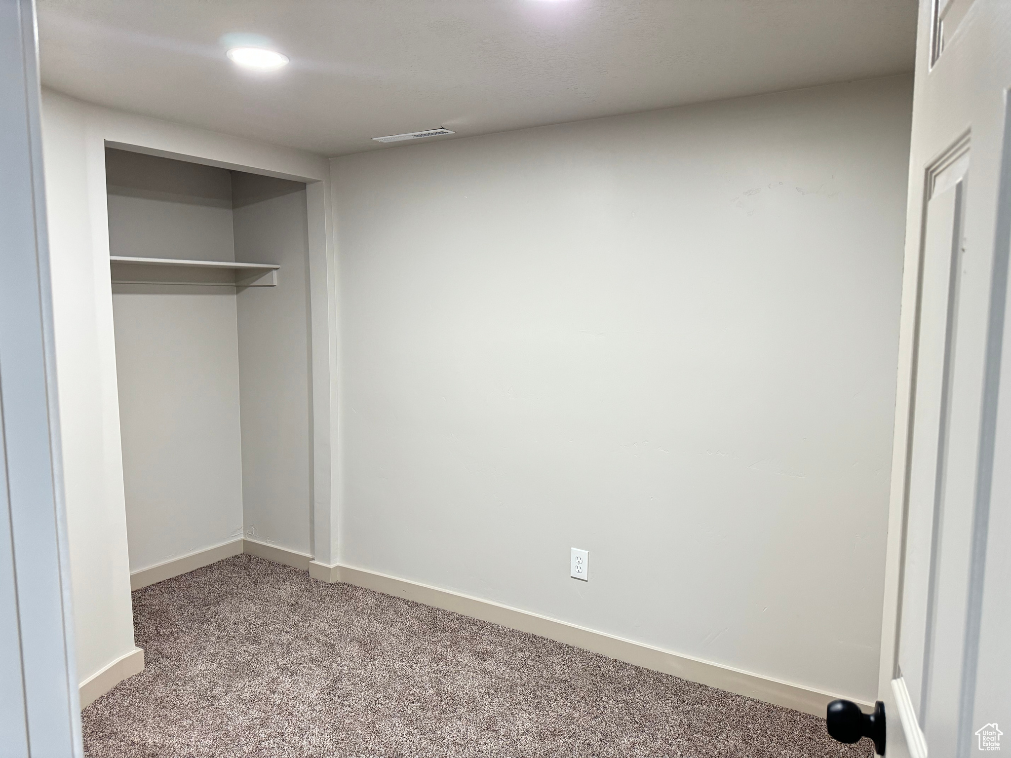 Unfurnished bedroom with a closet and light carpet