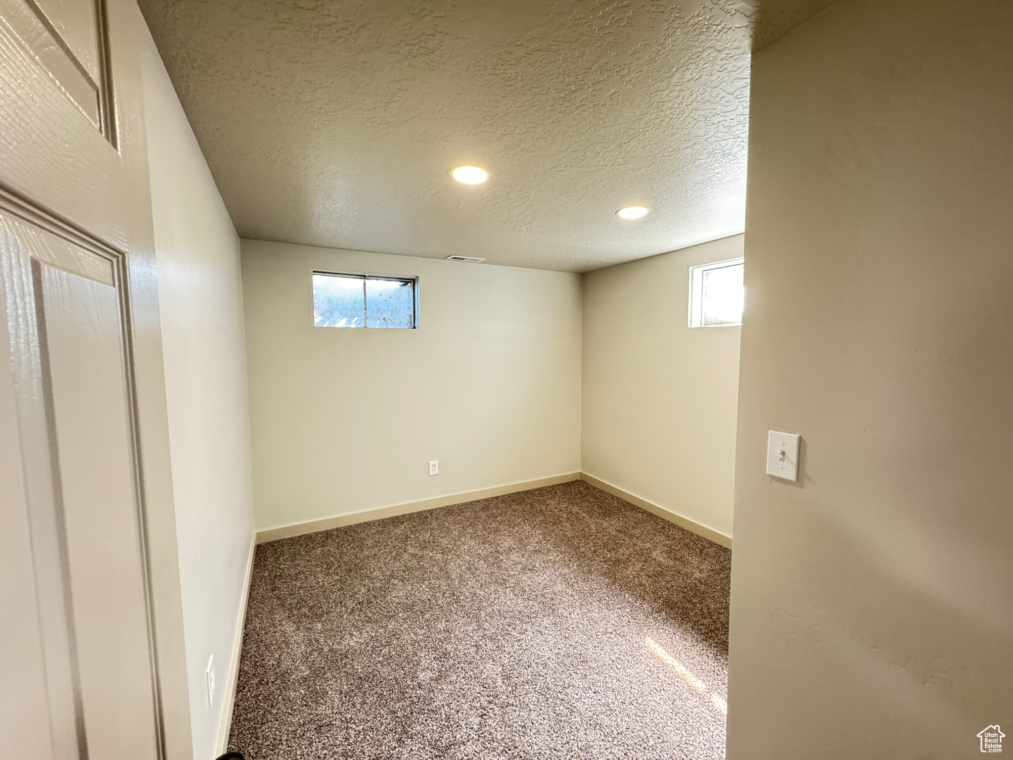 Interior space with a textured ceiling and carpet flooring