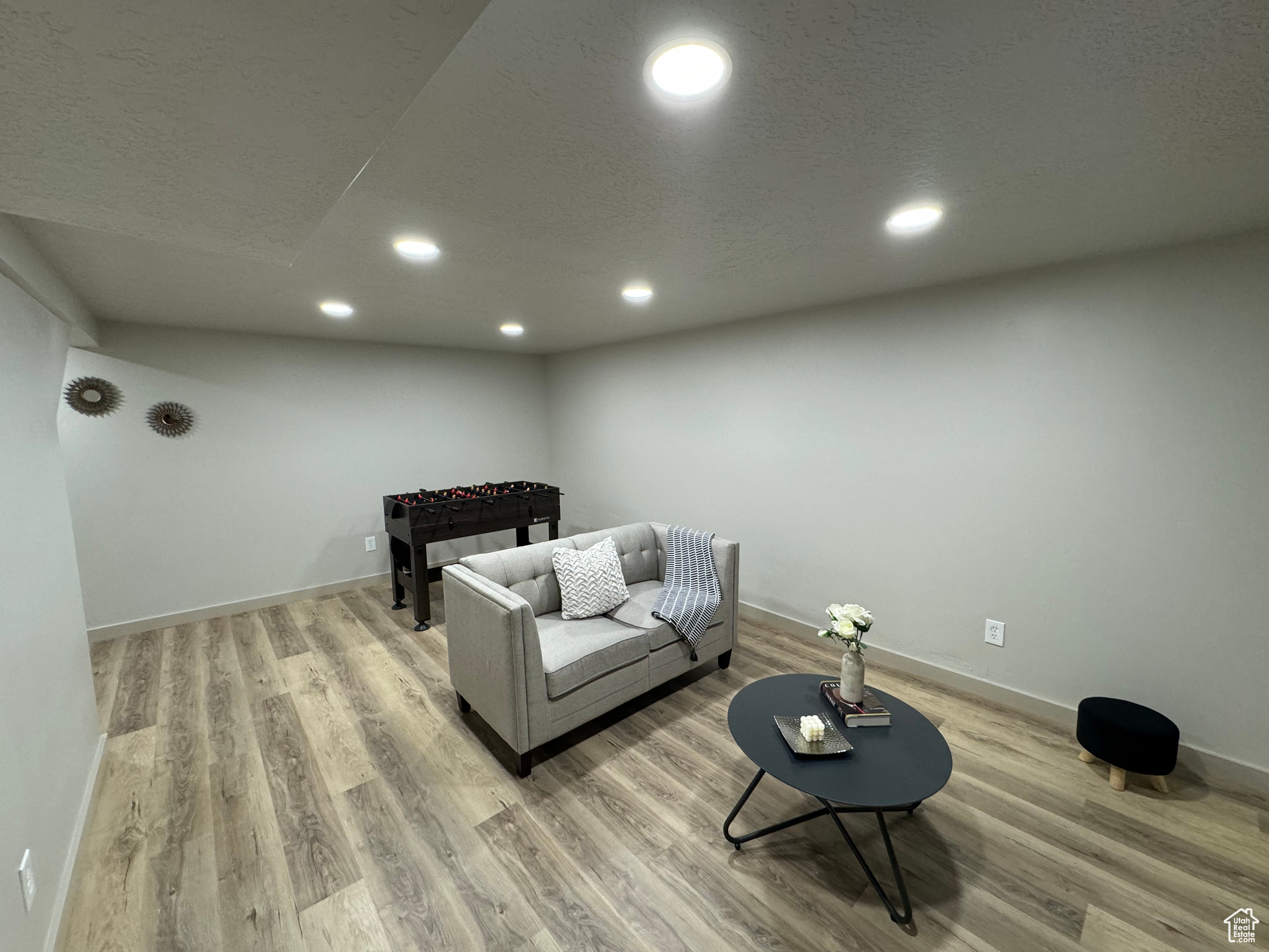 Living room featuring a textured ceiling and light hardwood / wood-style flooring