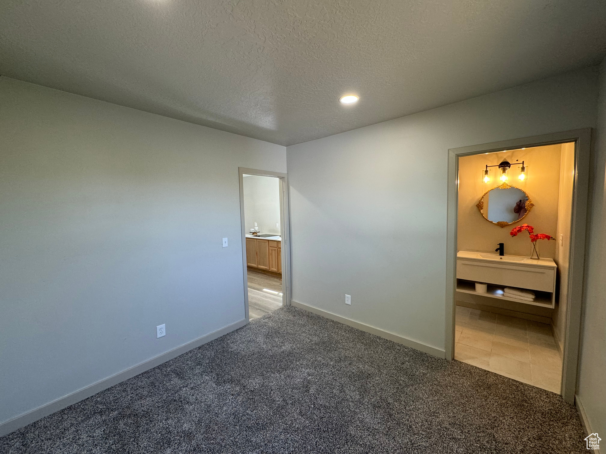 Unfurnished bedroom with a textured ceiling and carpet