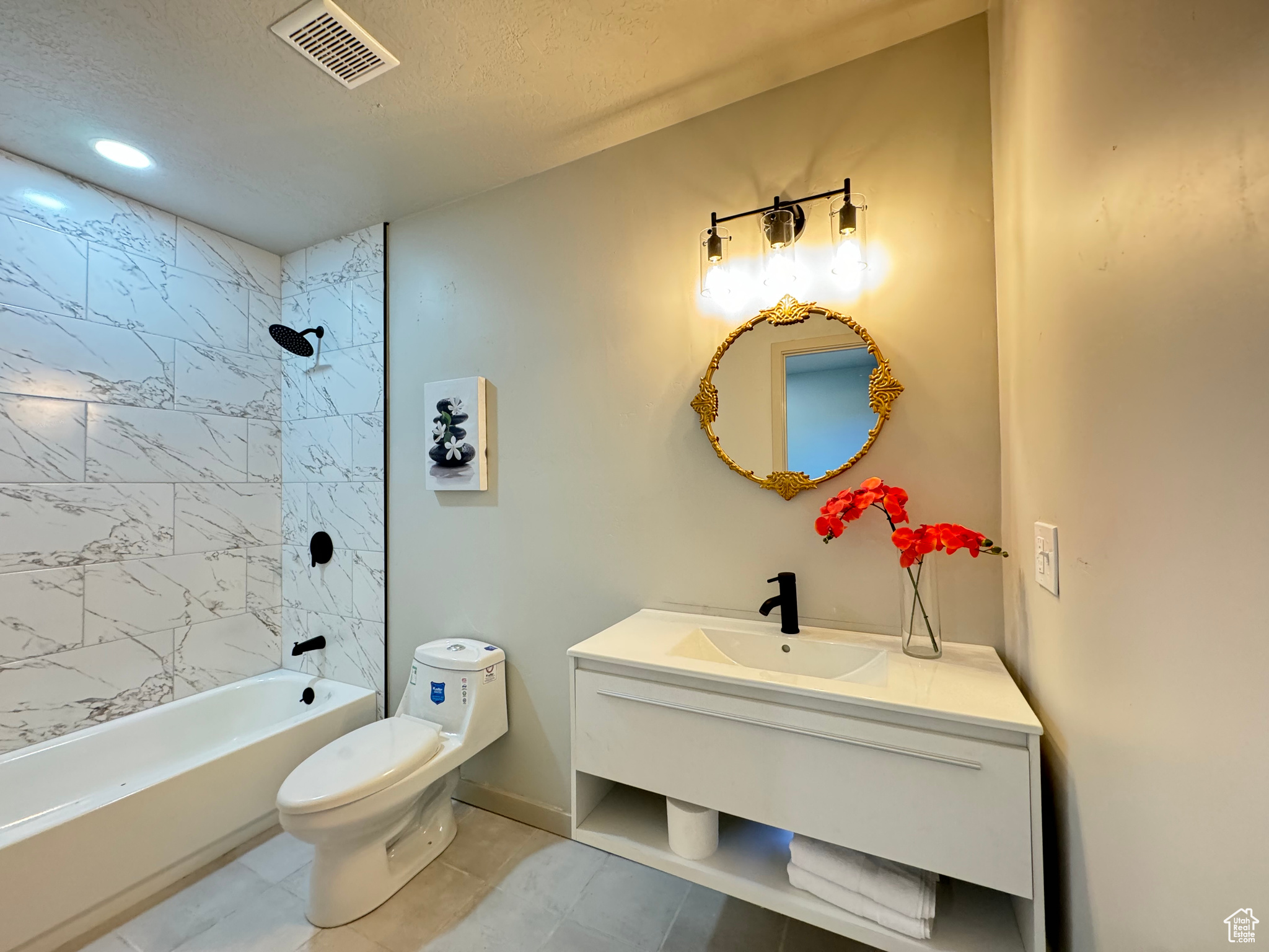 Full bathroom with tile patterned floors, tiled shower / bath, toilet, and vanity