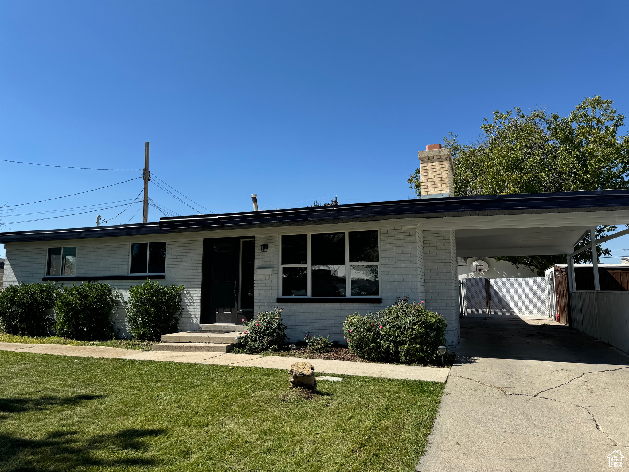 Ranch-style house featuring a front lawn and a carport