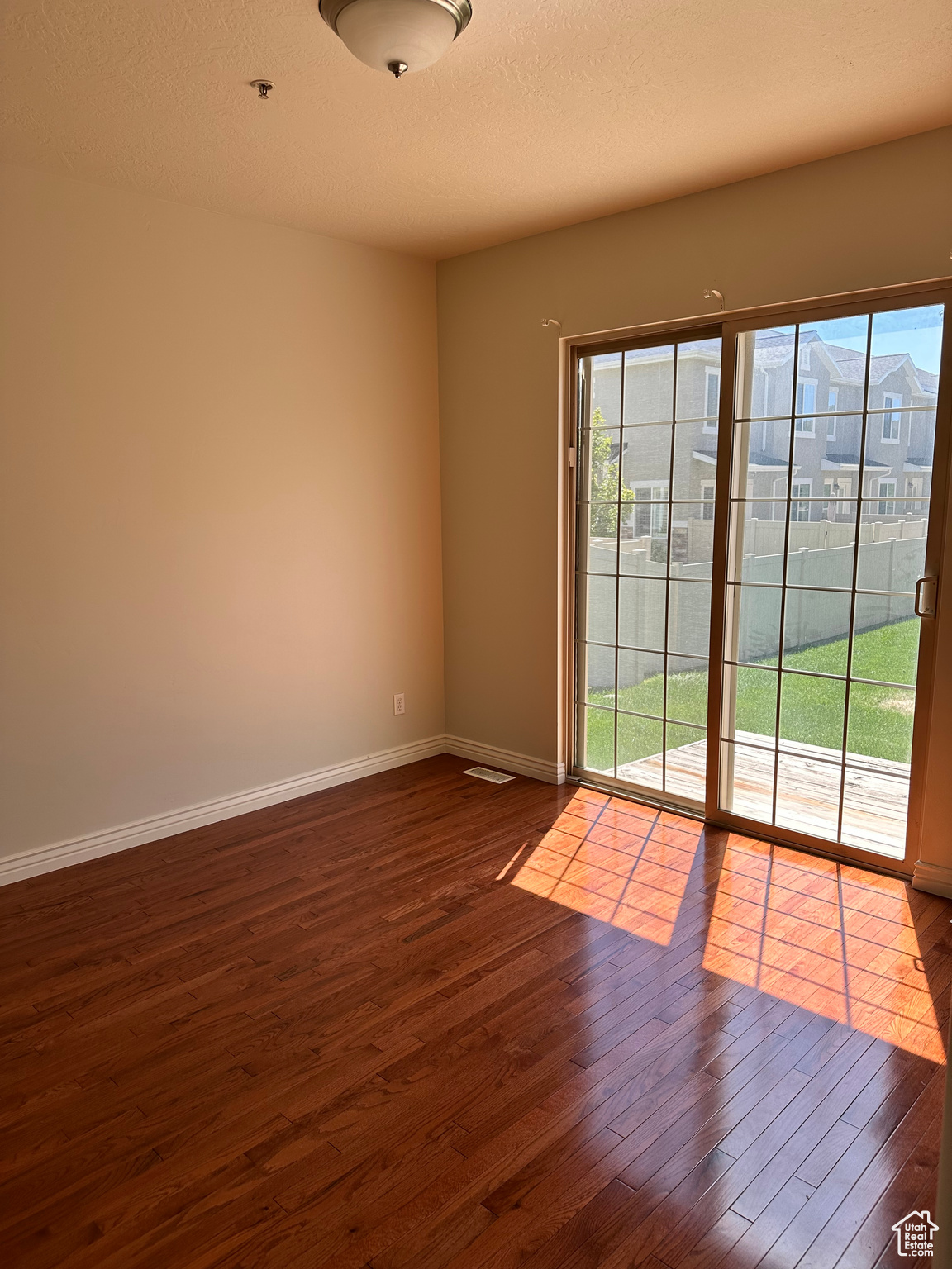 Empty room featuring dark hardwood / wood-style flooring and a textured ceiling