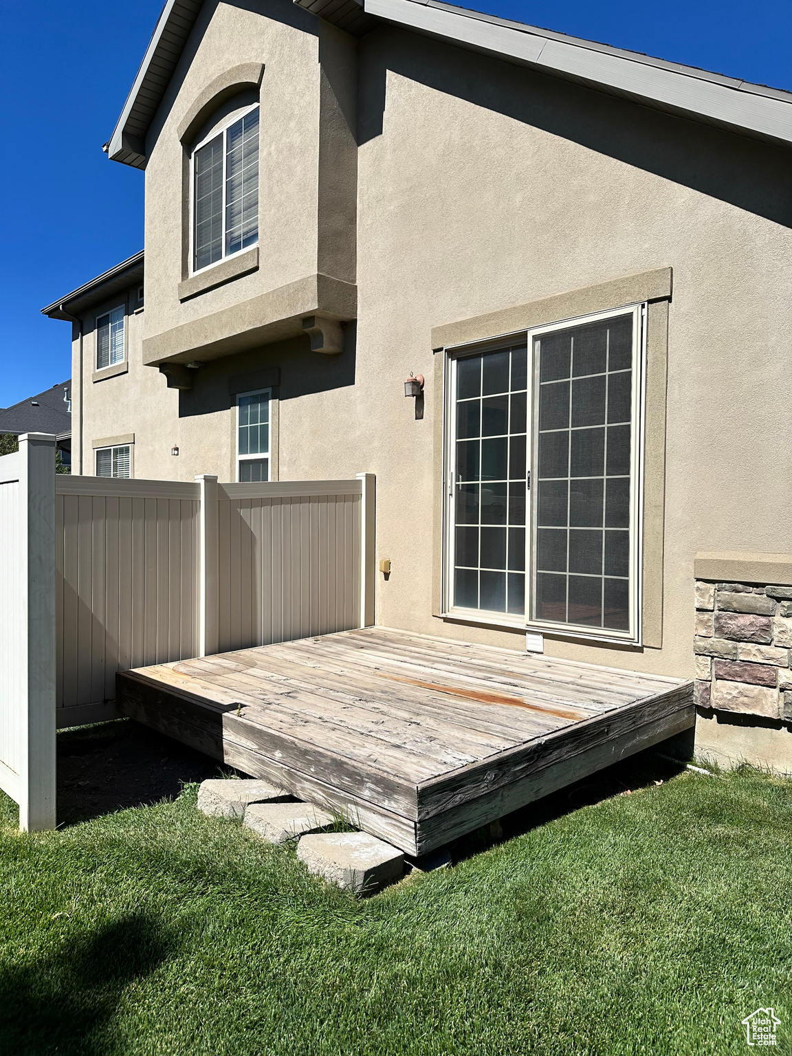 Rear view of house with a yard and a deck