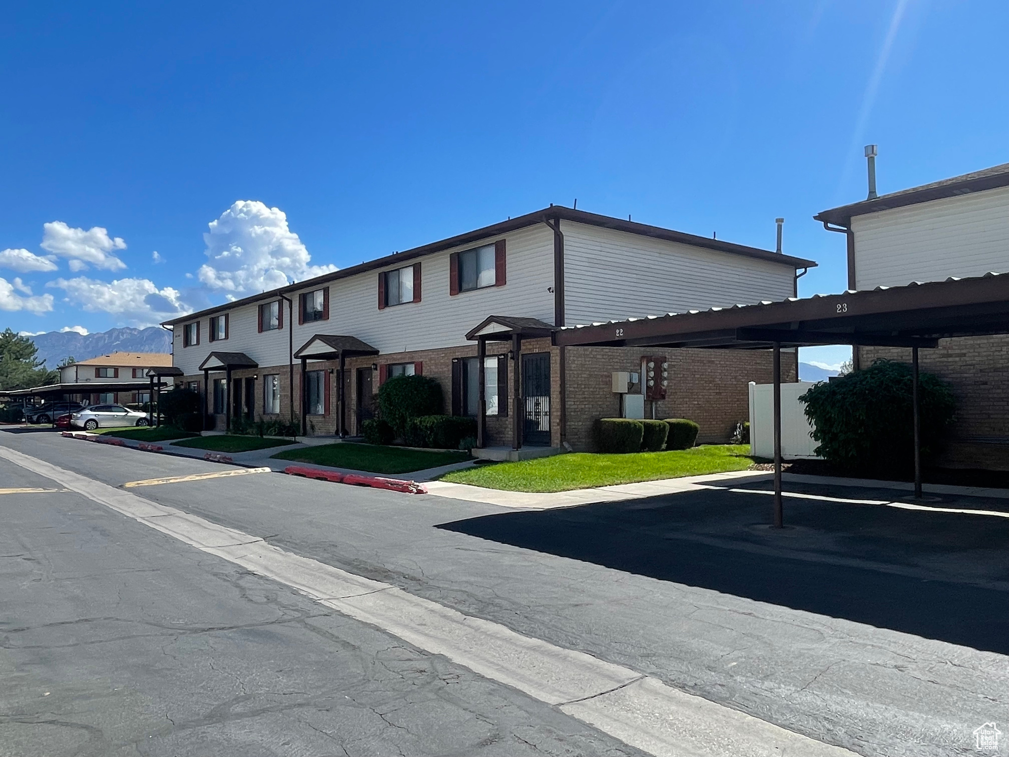 View of front of property featuring a mountain viewshowing front door and covered parking space.