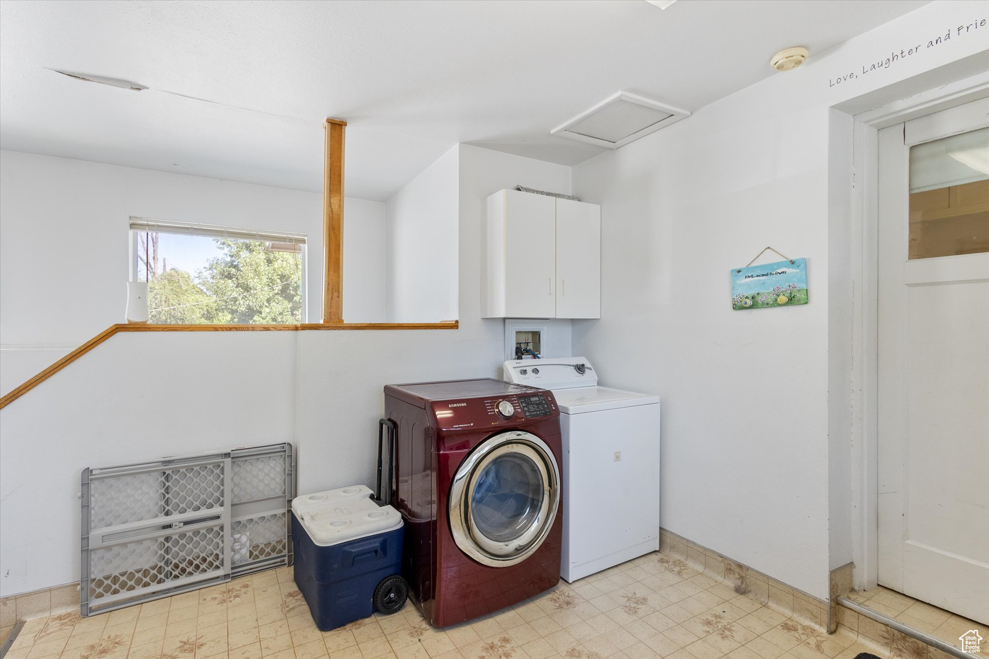 Clothes washing area featuring cabinets and washer and dryer