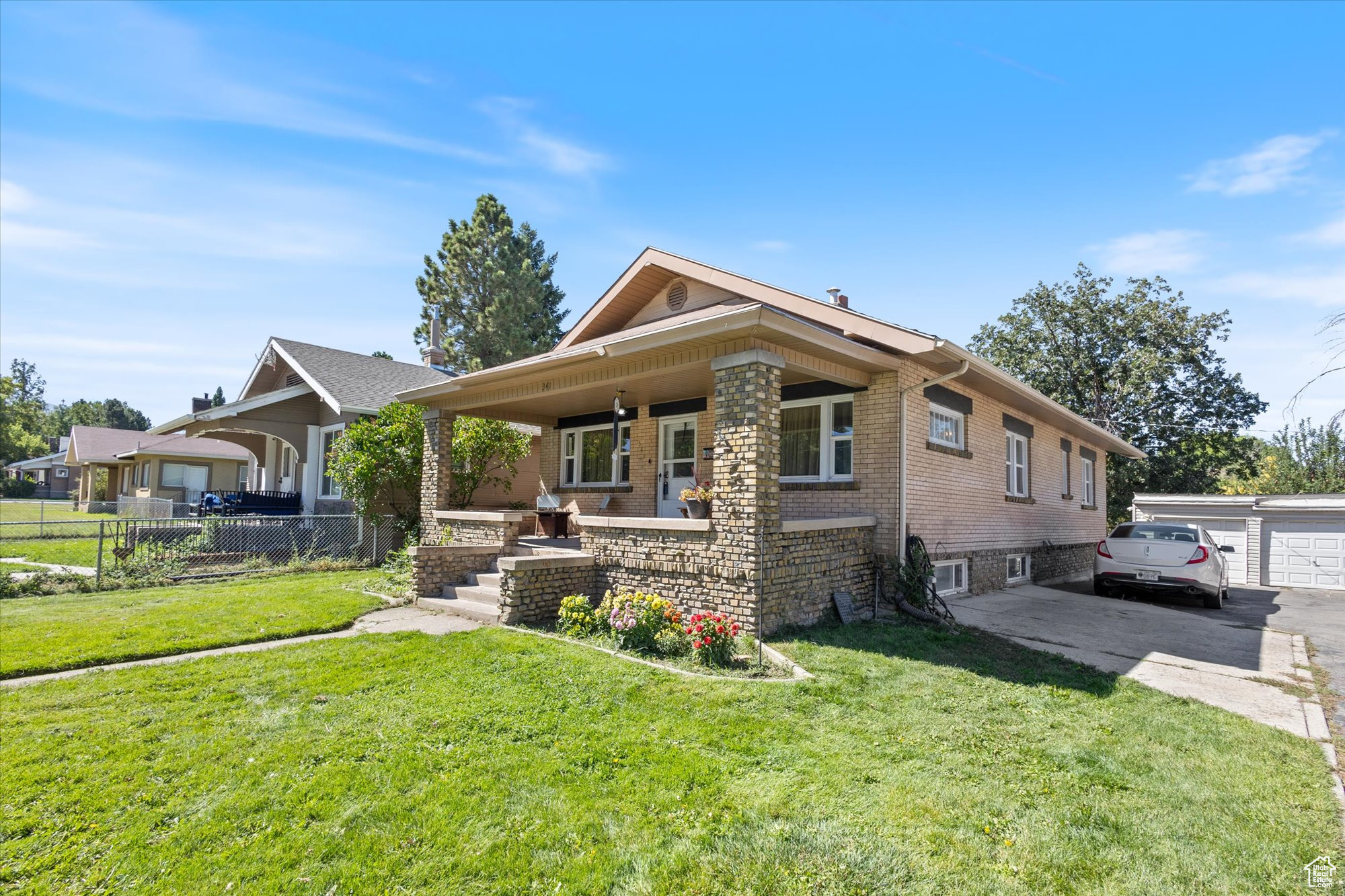 View of front of home featuring a garage, a porch, and a front lawn