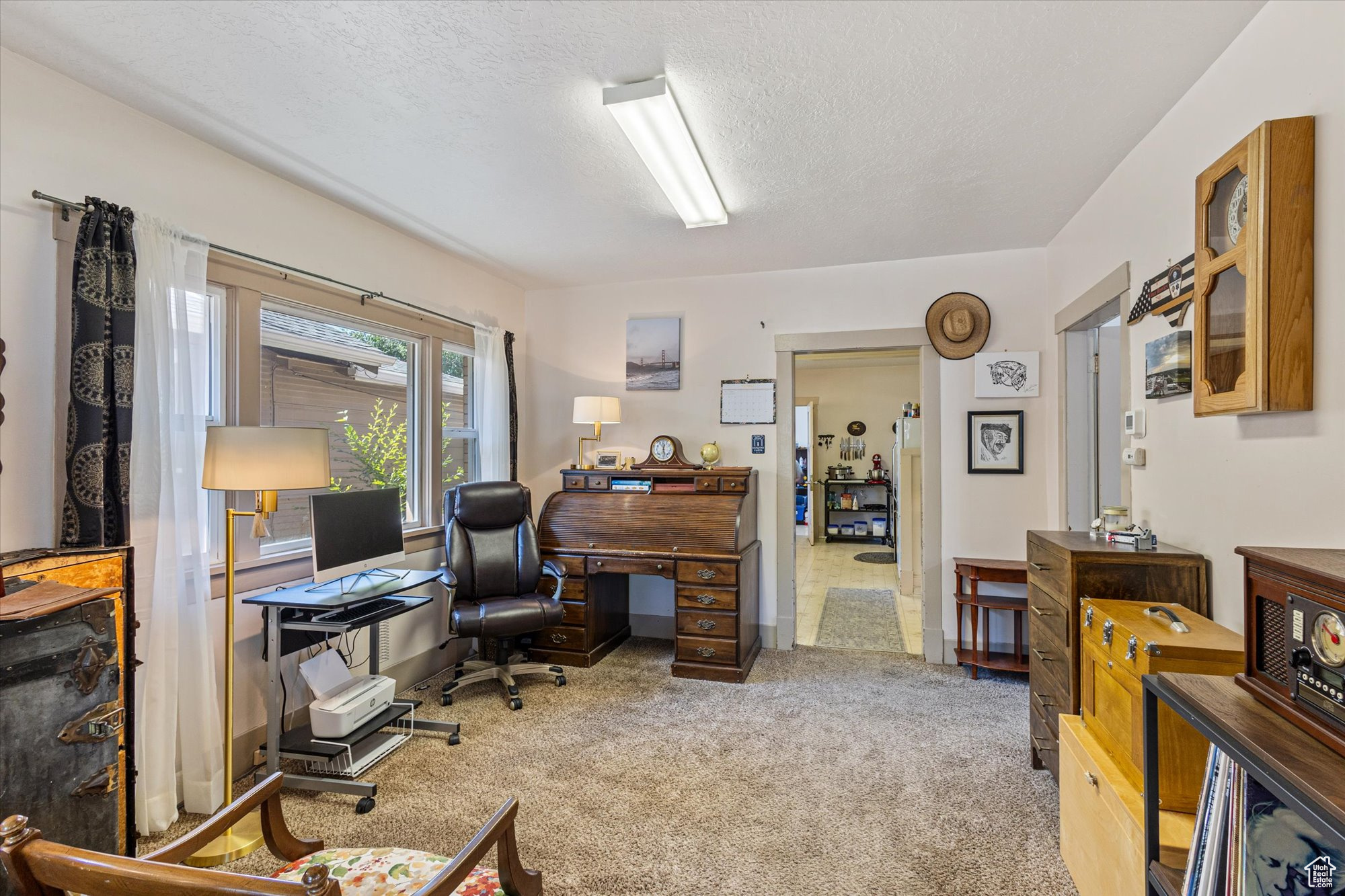 Carpeted office space featuring a textured ceiling