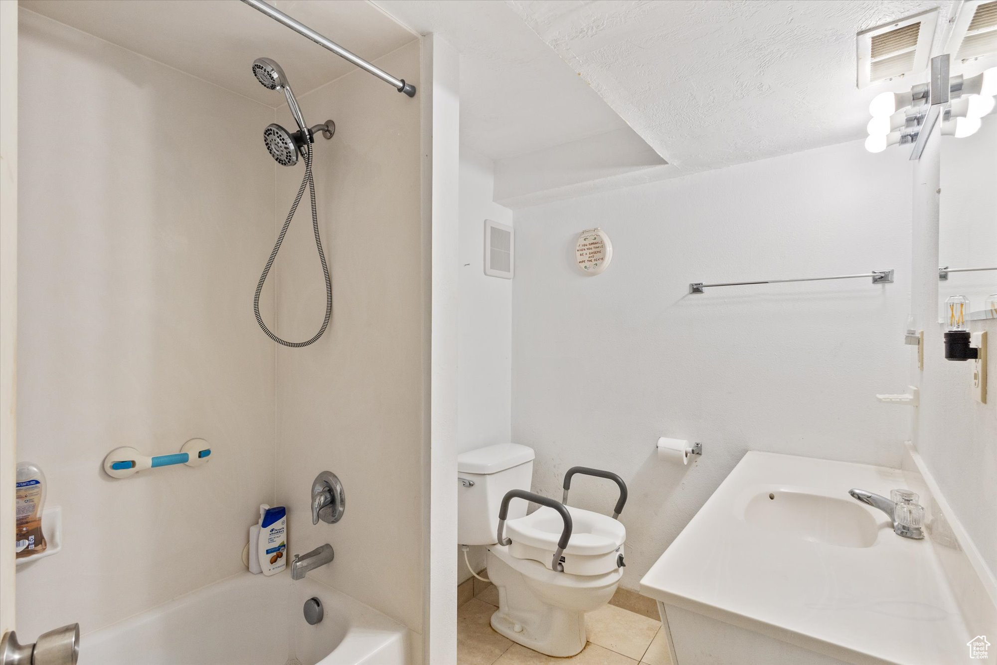 Full bathroom with a textured ceiling, vanity, toilet, shower / bathtub combination, and tile patterned floors