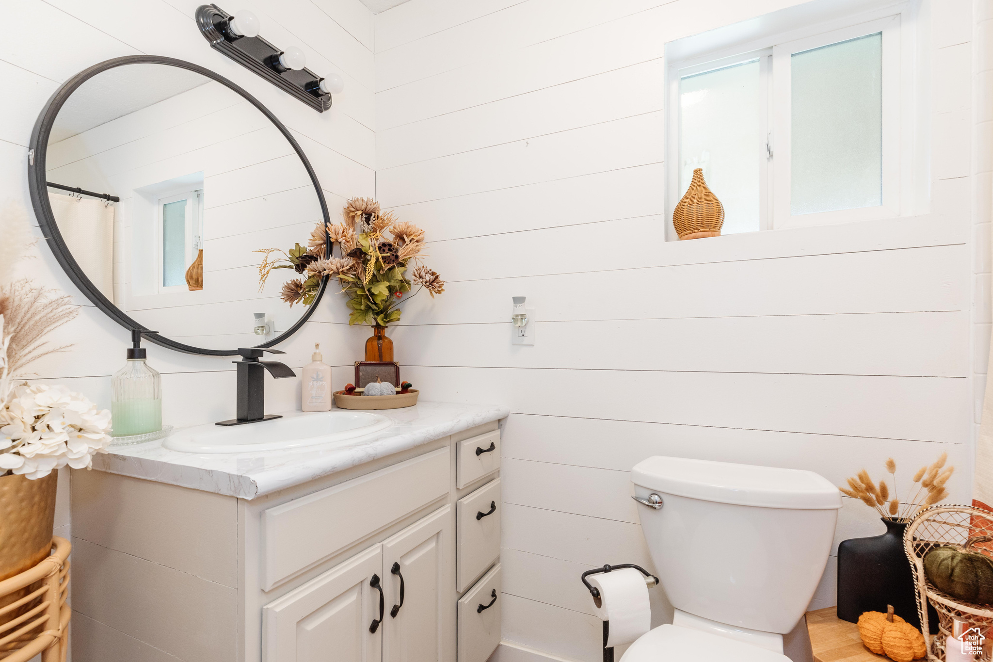 Bathroom featuring wood walls, vanity, and toilet