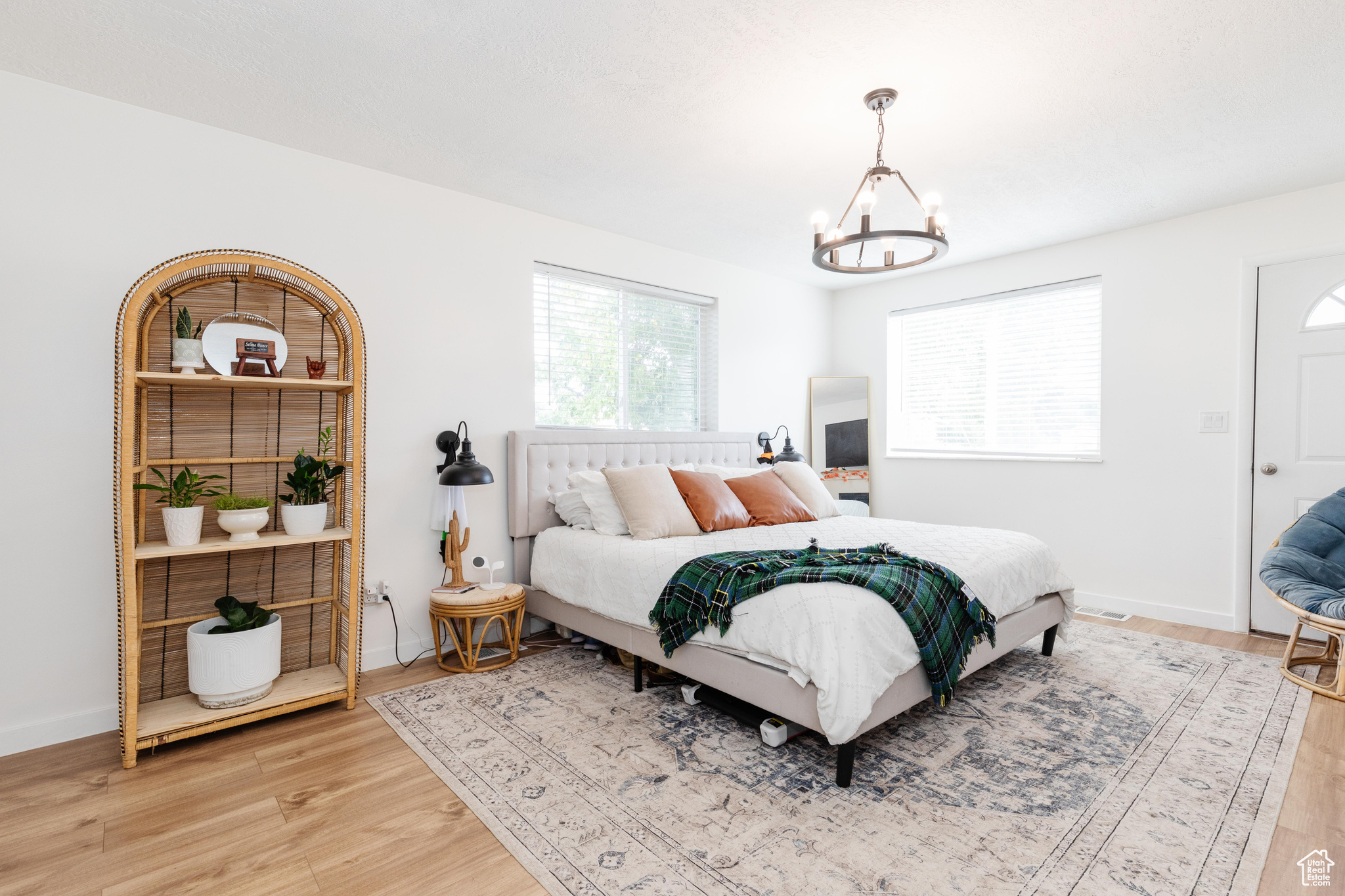 Bedroom with multiple windows, wood-type flooring, and a chandelier