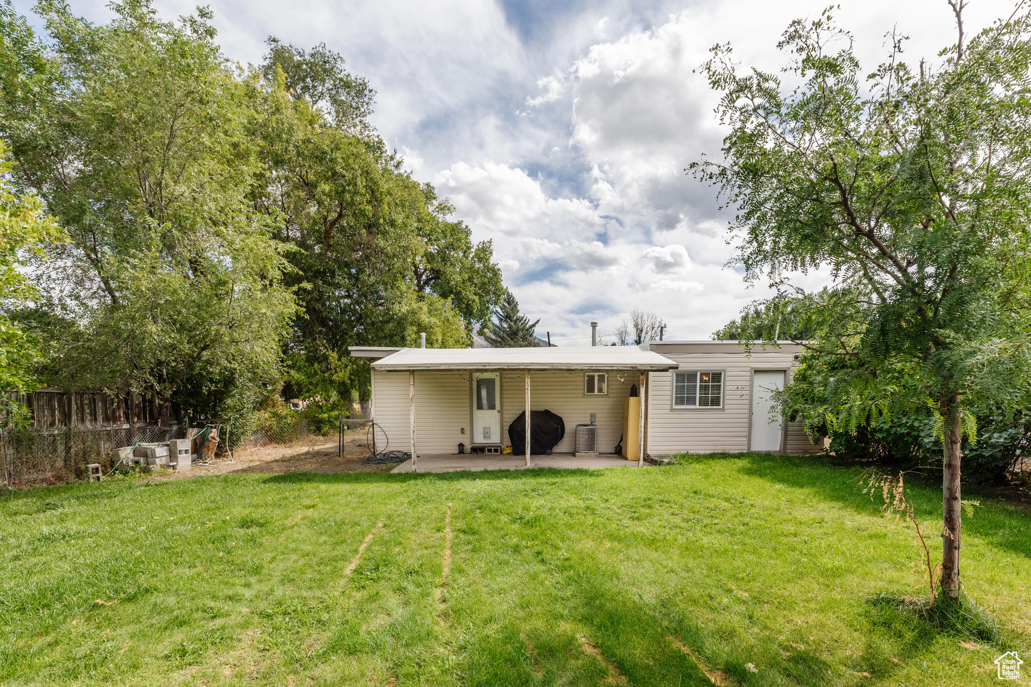 Rear view of property with a patio and a yard