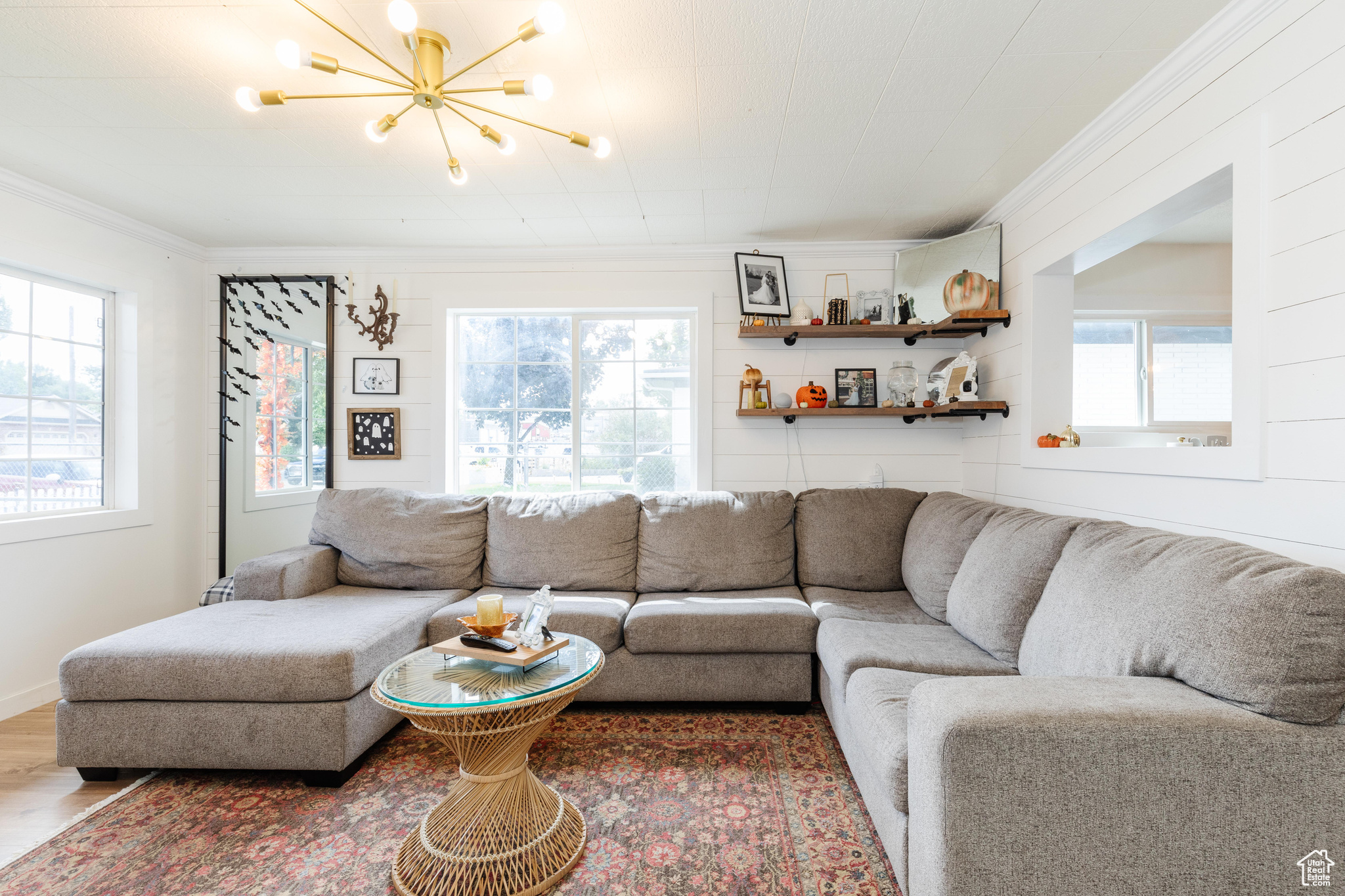 Living room featuring a healthy amount of sunlight, ornamental molding, and wood-type flooring