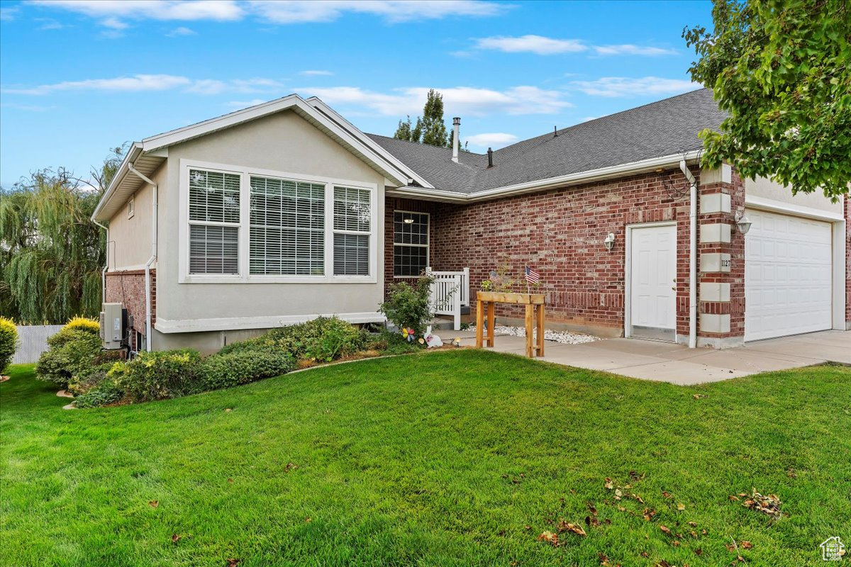 Ranch-style house with a front yard and a garage