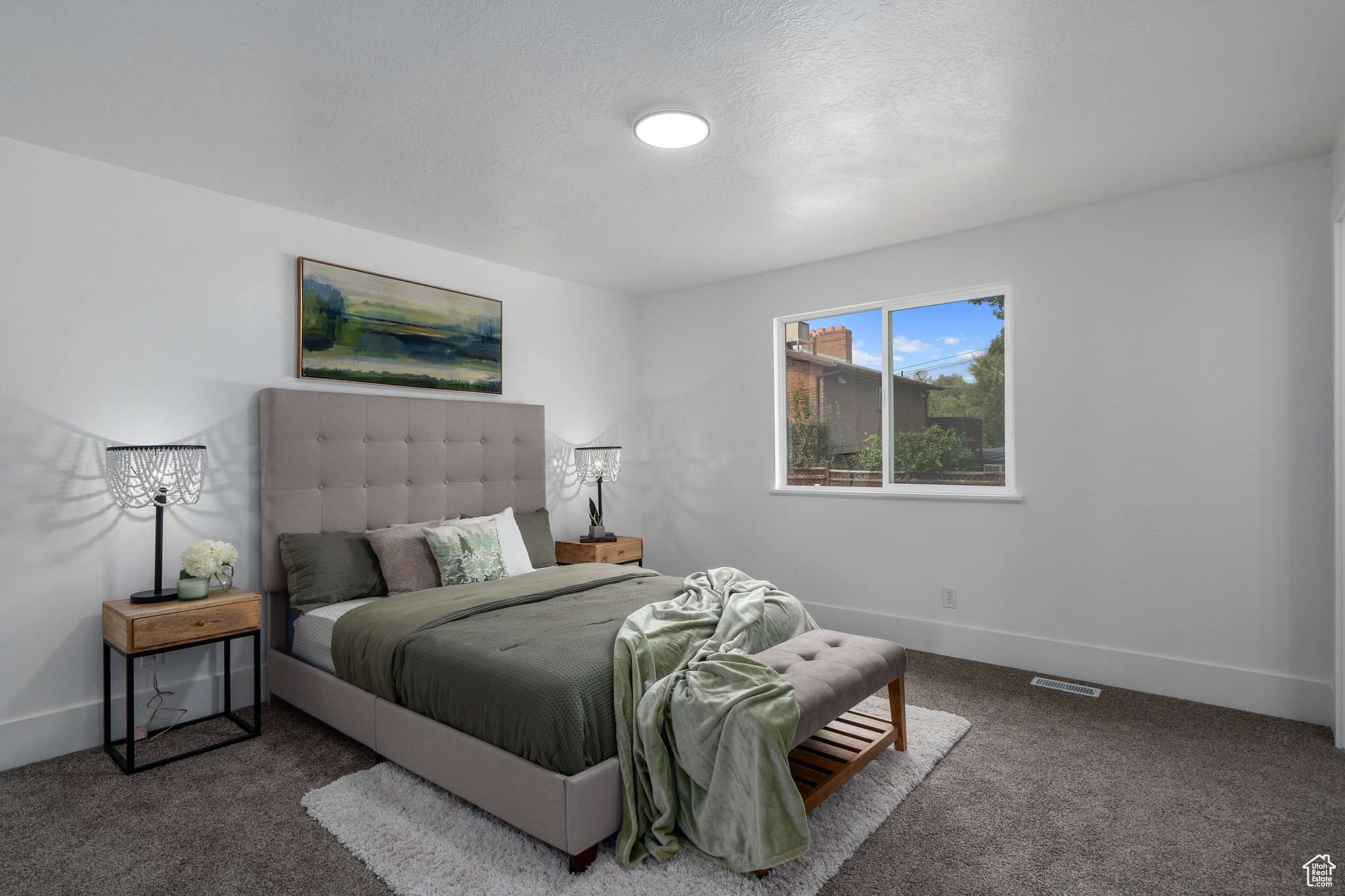 Bedroom with dark carpet and a textured ceiling