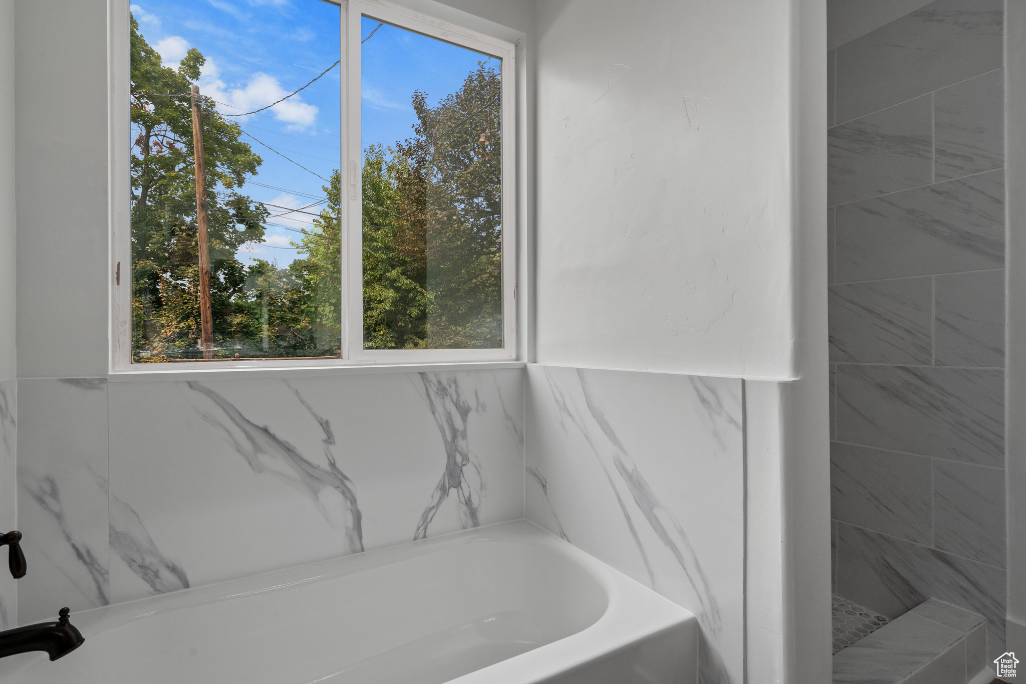 Bathroom featuring plus walk in shower and plenty of natural light