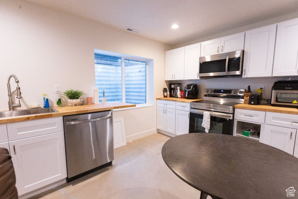 Kitchen featuring sink, stainless steel appliances, and white cabinets