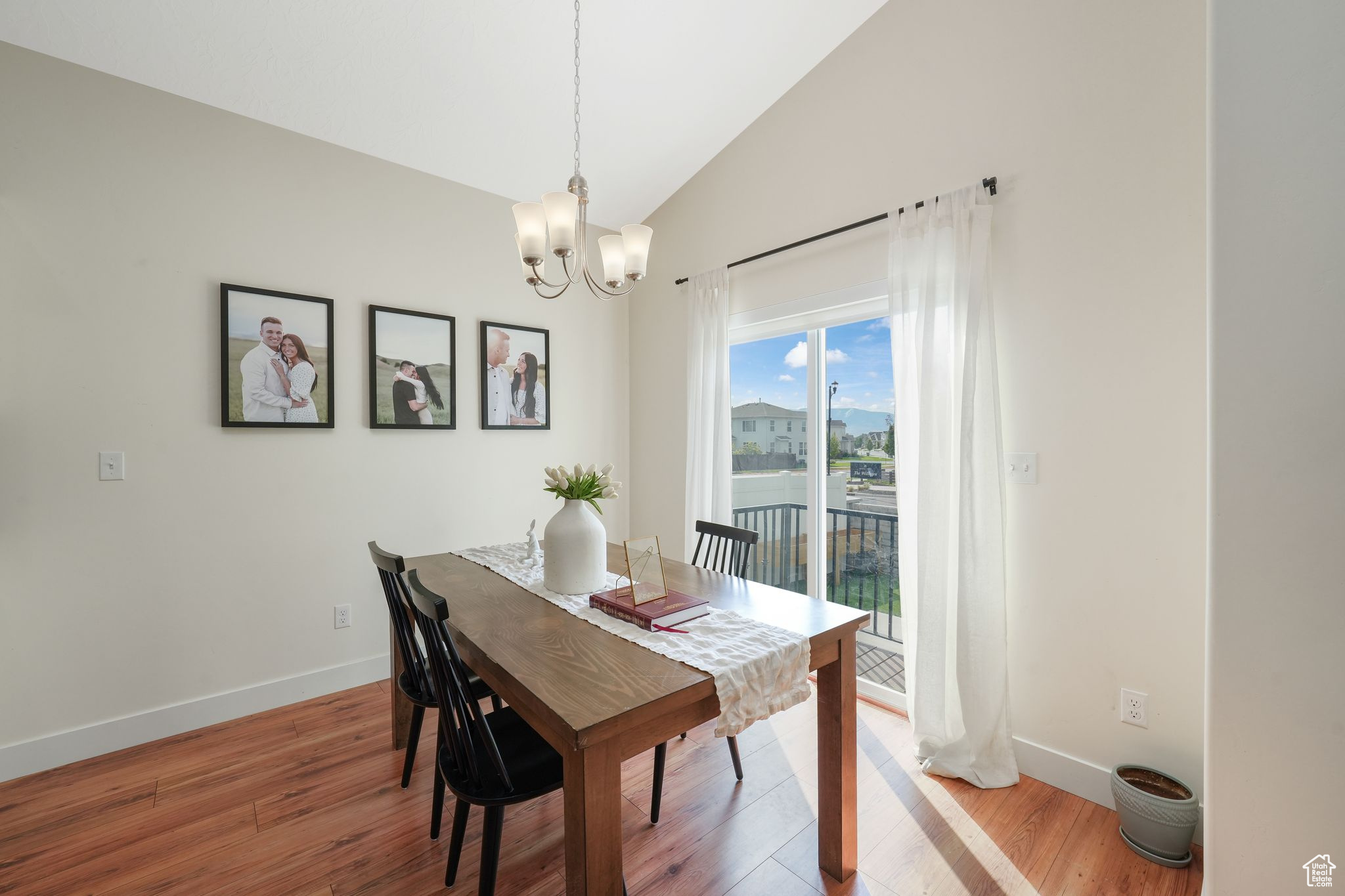 Dining area featuring lofted ceiling, hardwood / wood-style flooring, and a notable chandelier