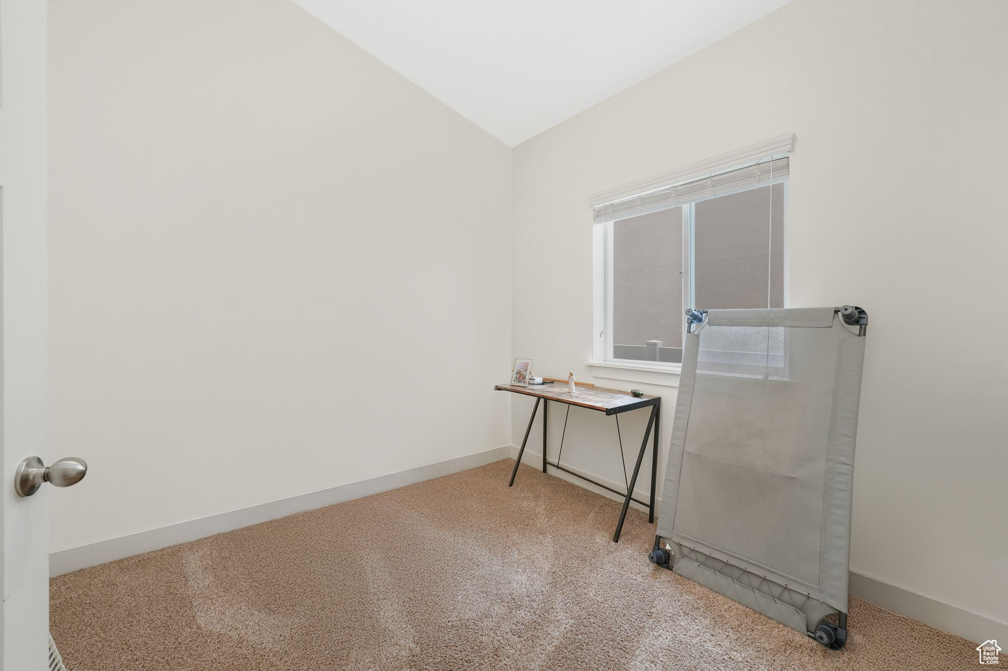 Unfurnished room with lofted ceiling and light colored carpet