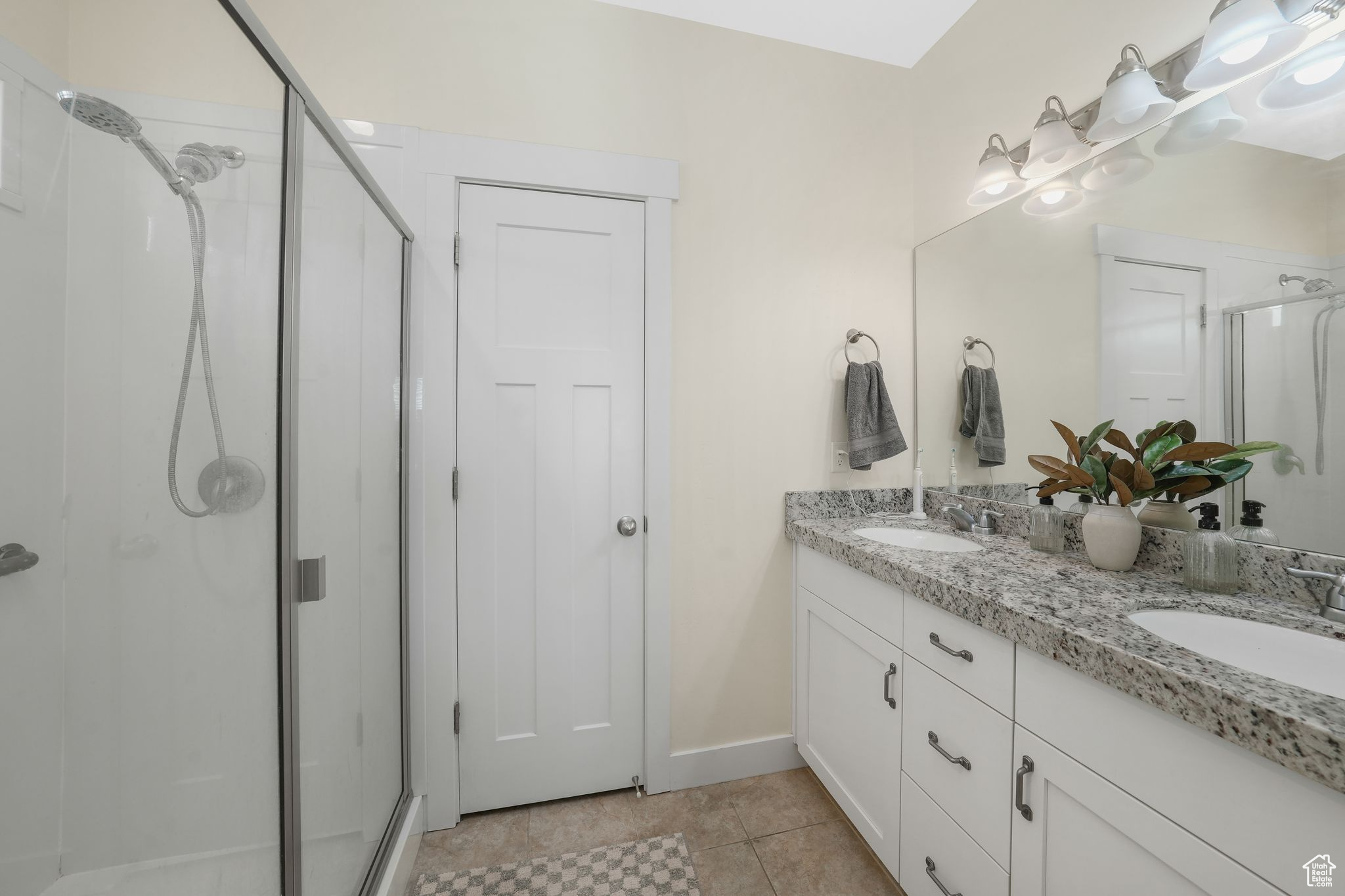 Bathroom with tile patterned flooring, vanity, and a shower with shower door