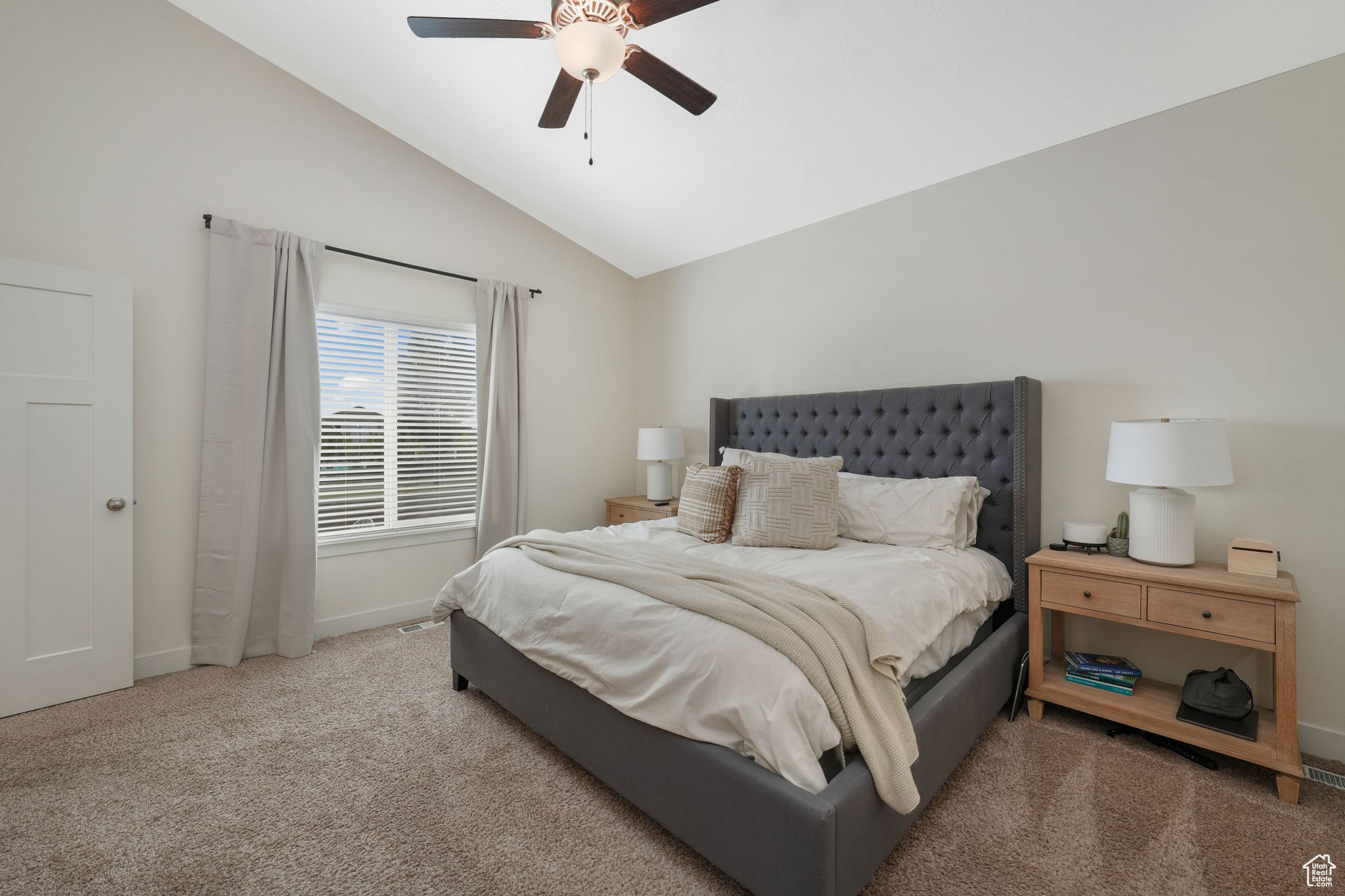 Bedroom featuring vaulted ceiling, ceiling fan, and carpet flooring