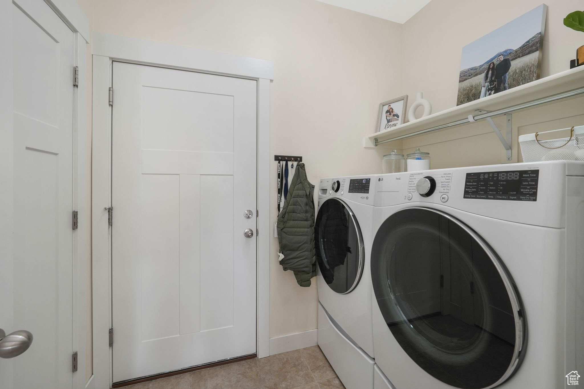 Laundry room featuring washer and dryer and light tile patterned floors