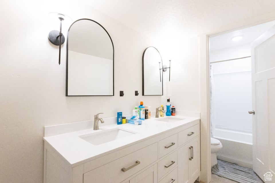 Full bathroom with vanity, toilet, and shower / bathtub combination with curtain