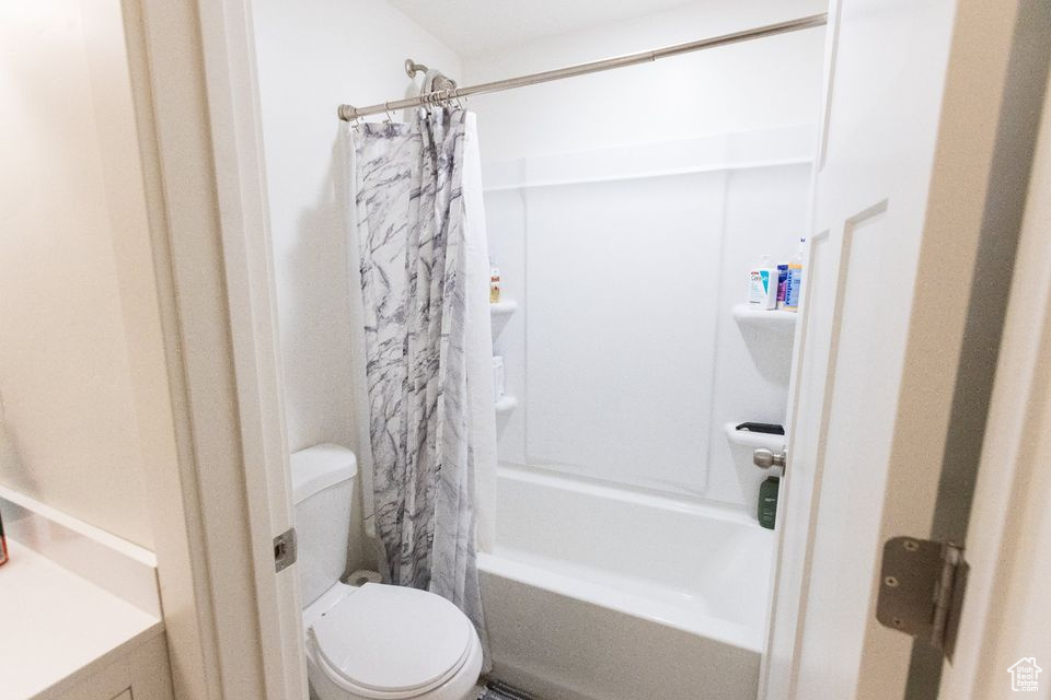 Full bathroom featuring shower / tub combo with curtain, vanity, and toilet