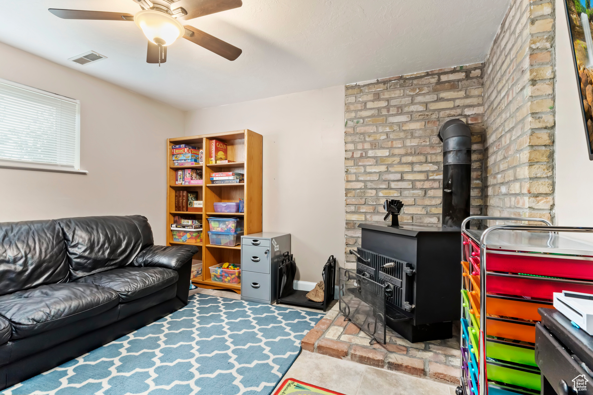 Interior space featuring ceiling fan and a wood stove