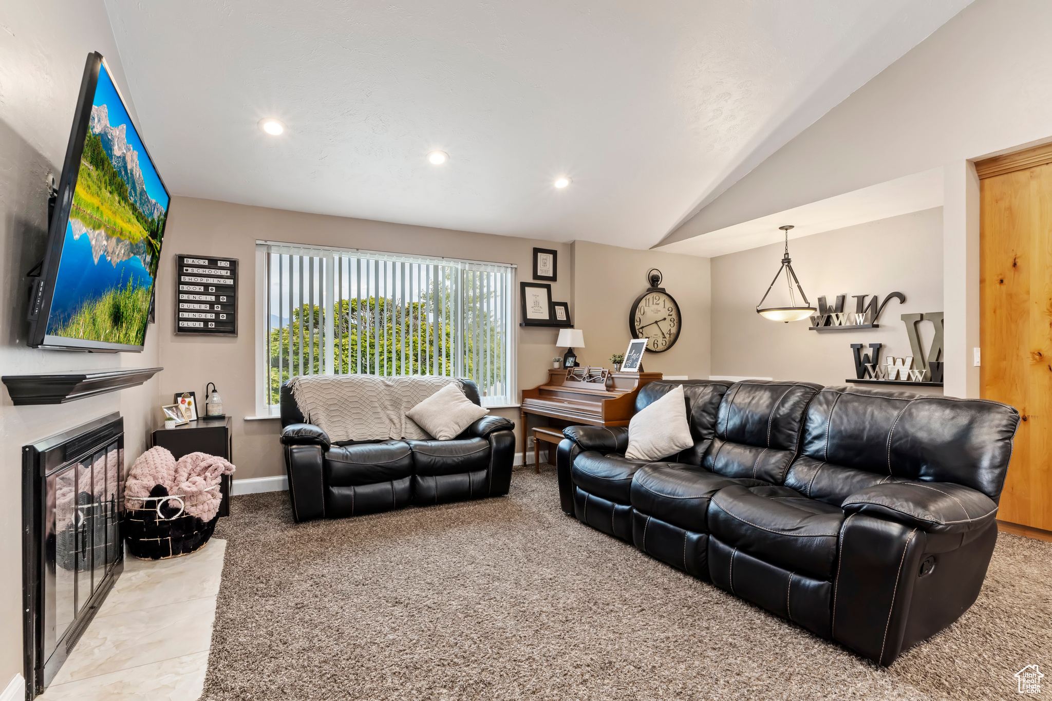 Carpeted living room with vaulted ceiling