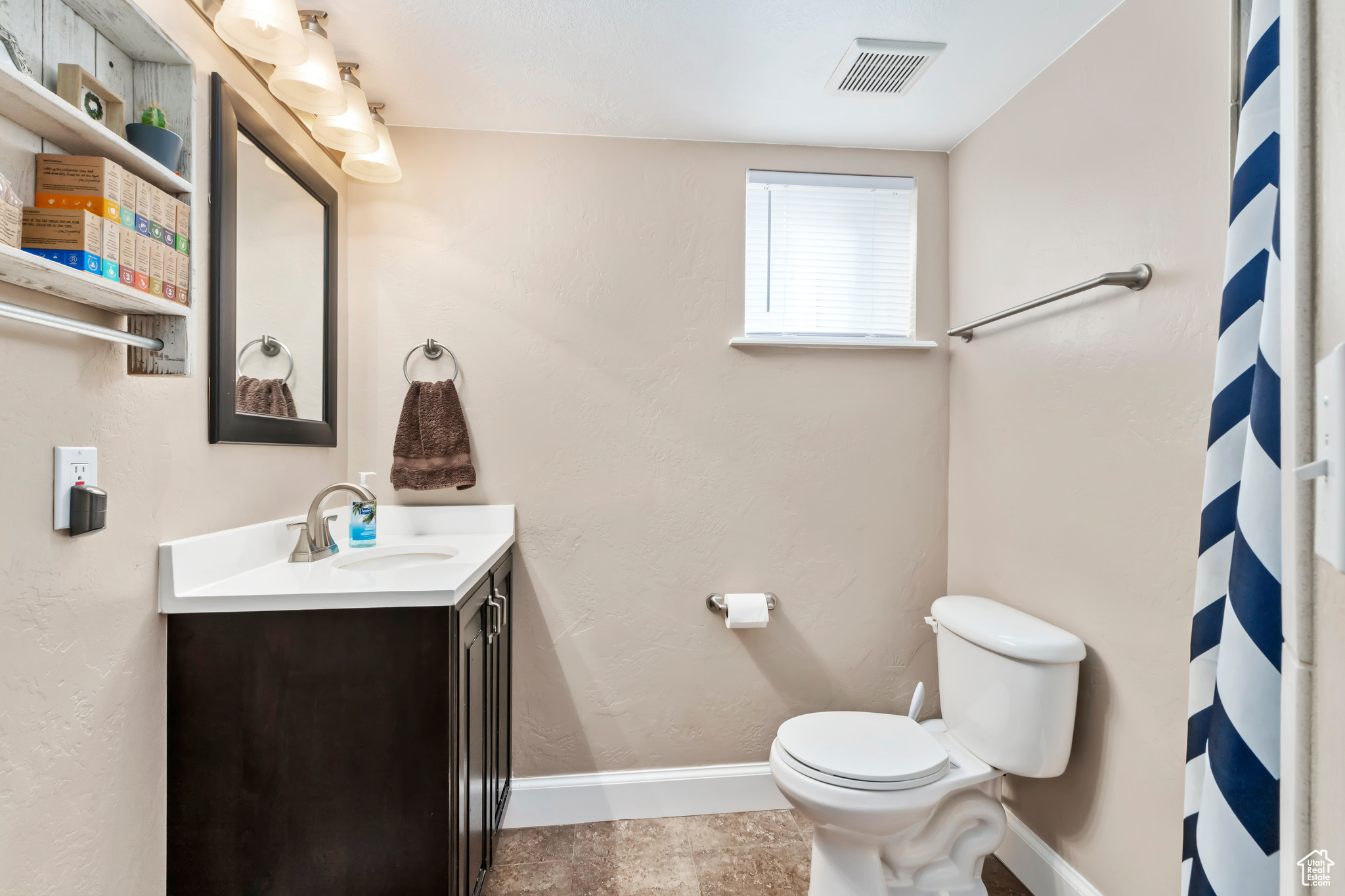 Bathroom featuring vanity, toilet, and tile patterned floors