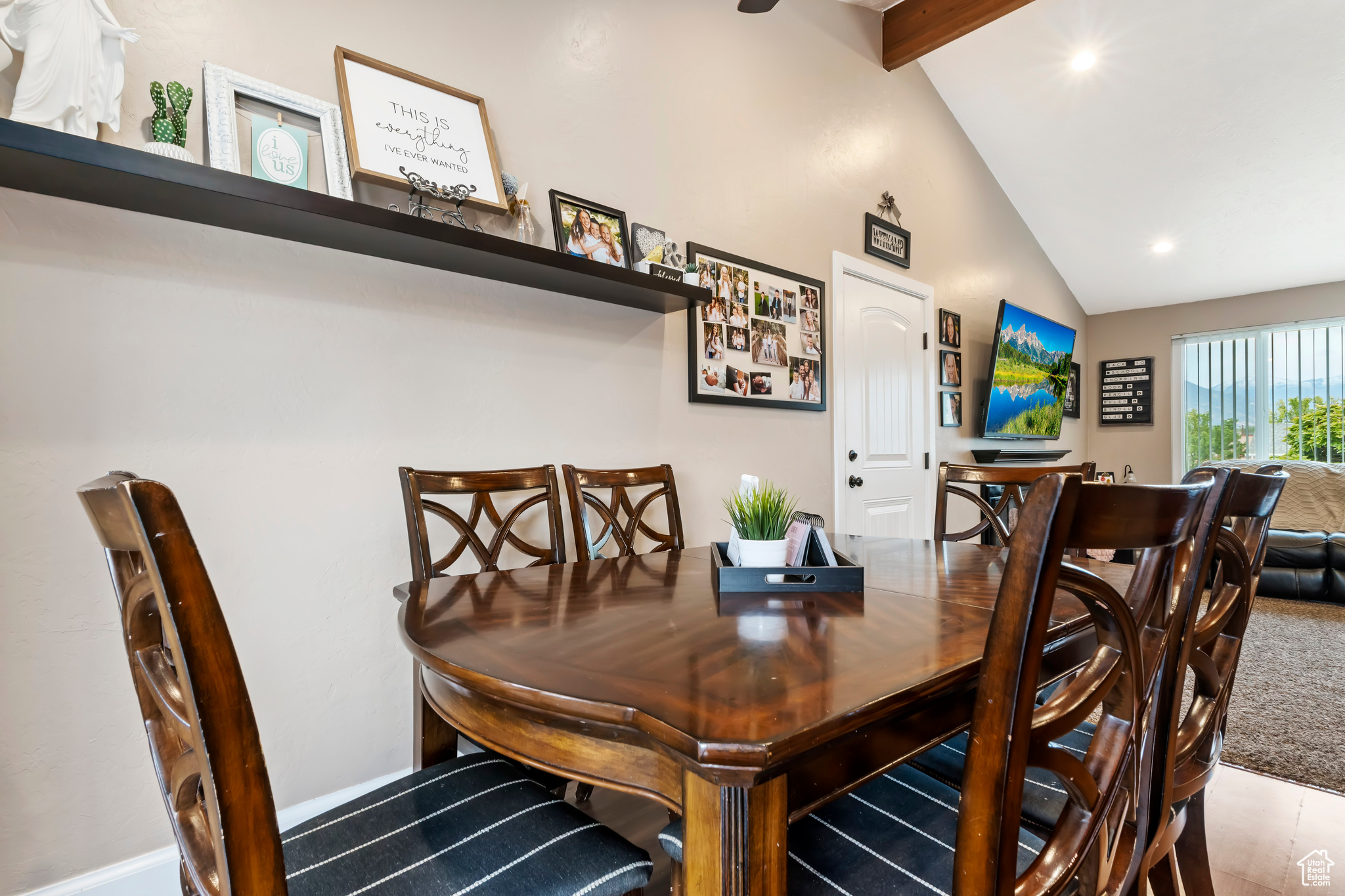 Carpeted dining area with lofted ceiling with beams