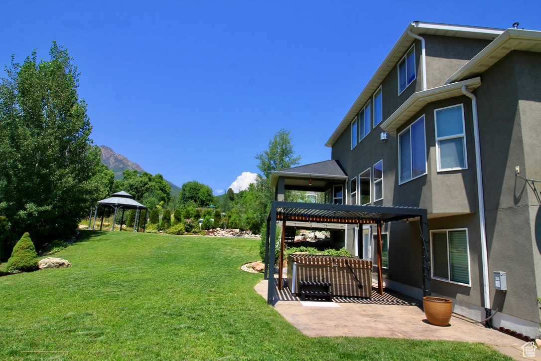 View of yard with a patio area, a mountain view, a pergola, and a gazebo