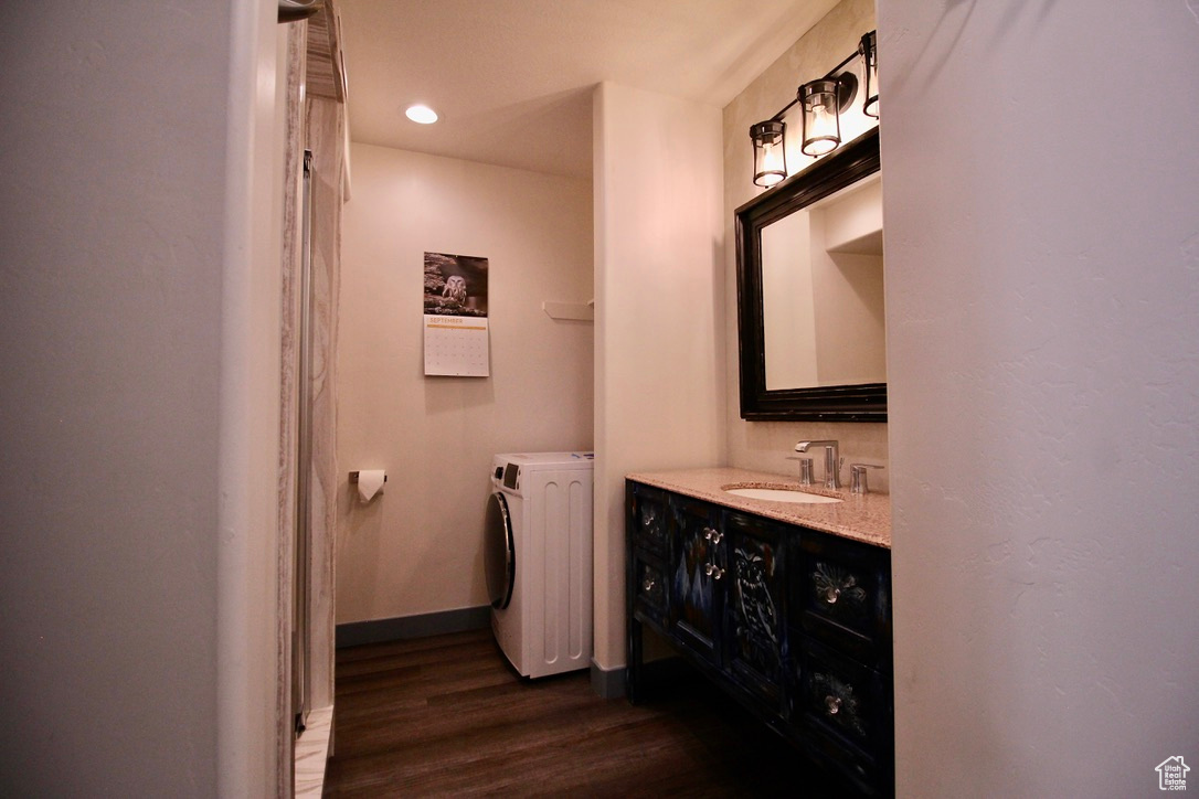 Bathroom with shower, washer/dryer, and vanity.