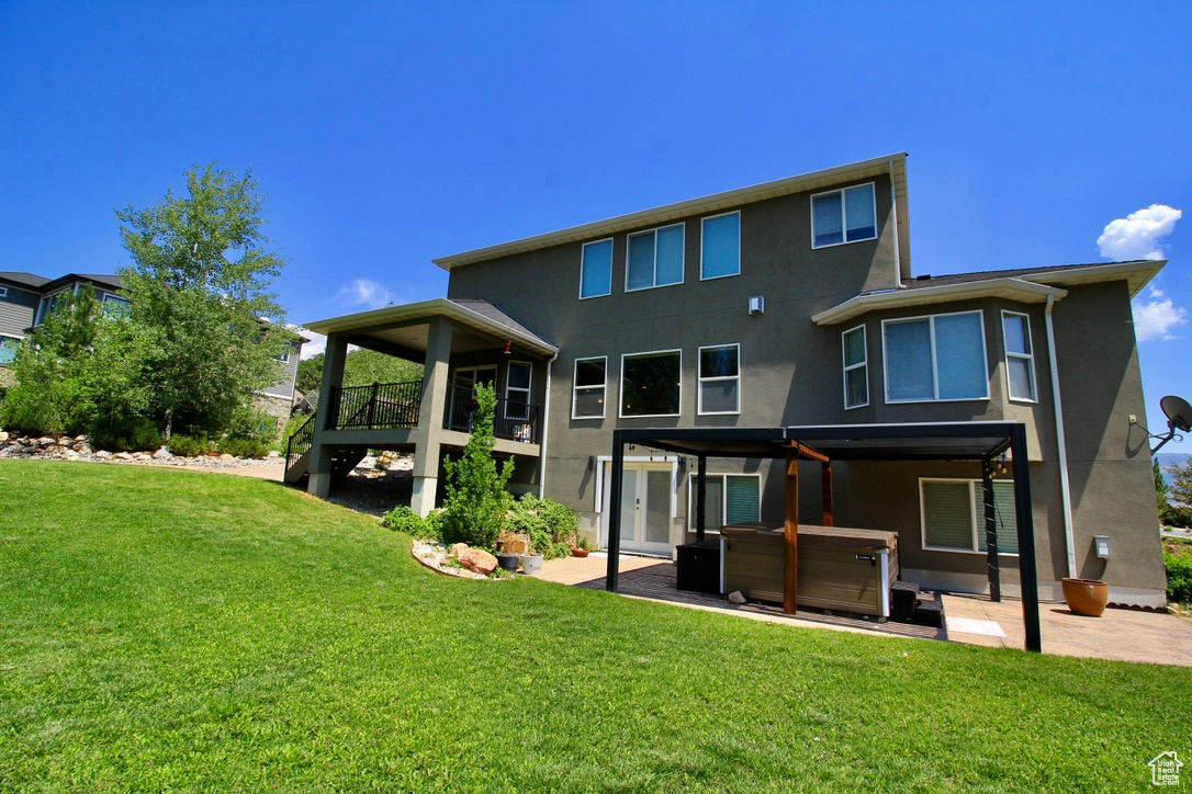 Back of property with a yard and a patio area