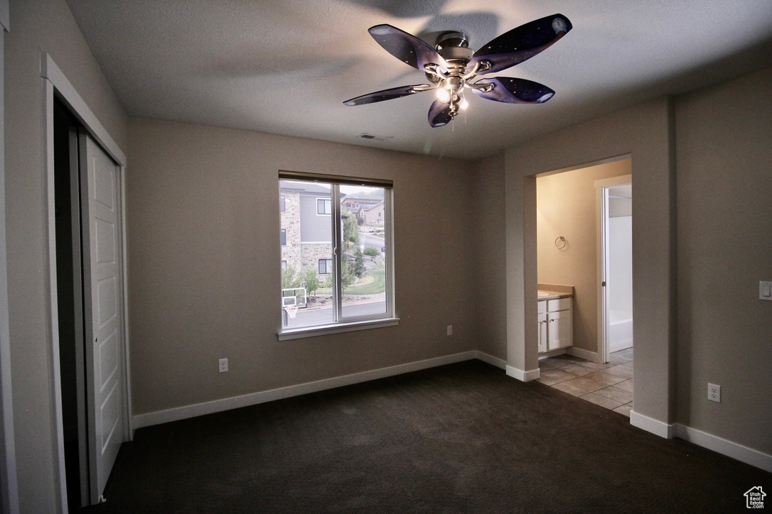 Bedroom featuring a textured ceiling, carpet, ceiling fan, and ensuite bath