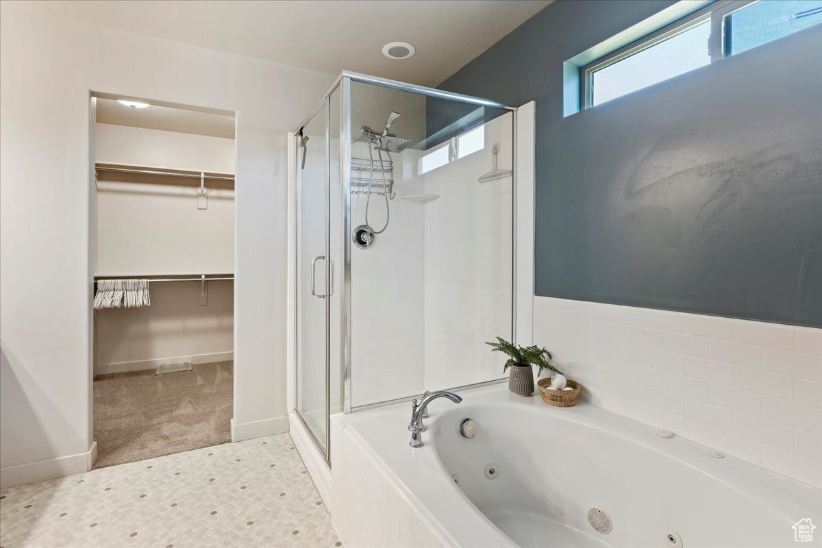 Primary bathroom with dual vanity, separate tub and shower, private toilet and walk-in closet