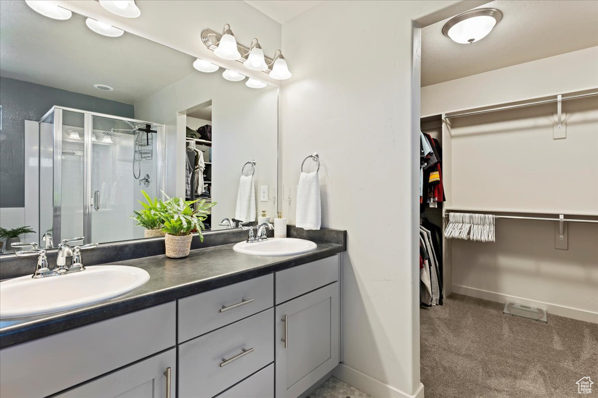 Primary bathroom with dual vanity, separate tub and shower, private toilet and walk-in closet