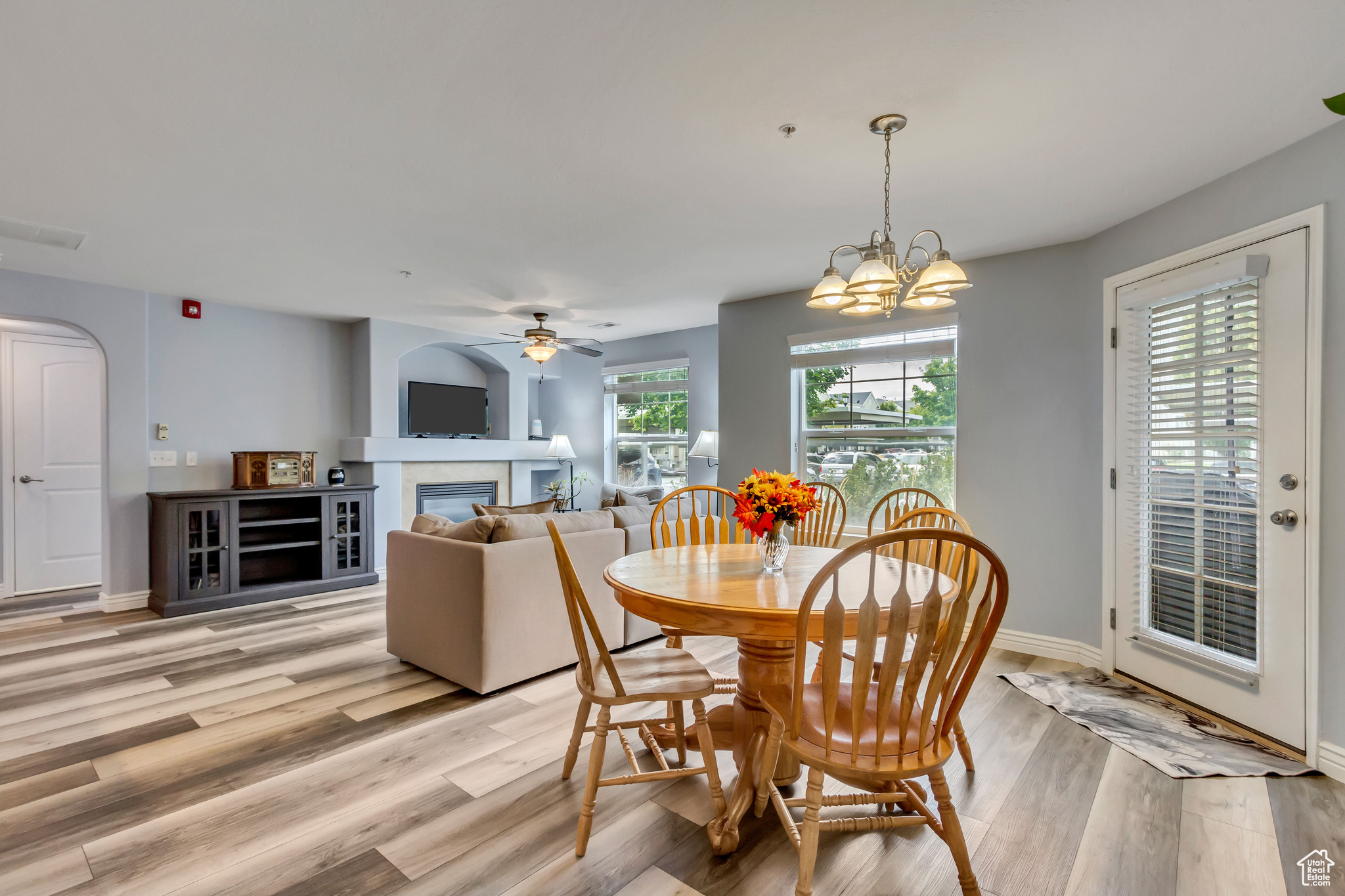 Dining space with ceiling fan and light hardwood / wood-style flooring