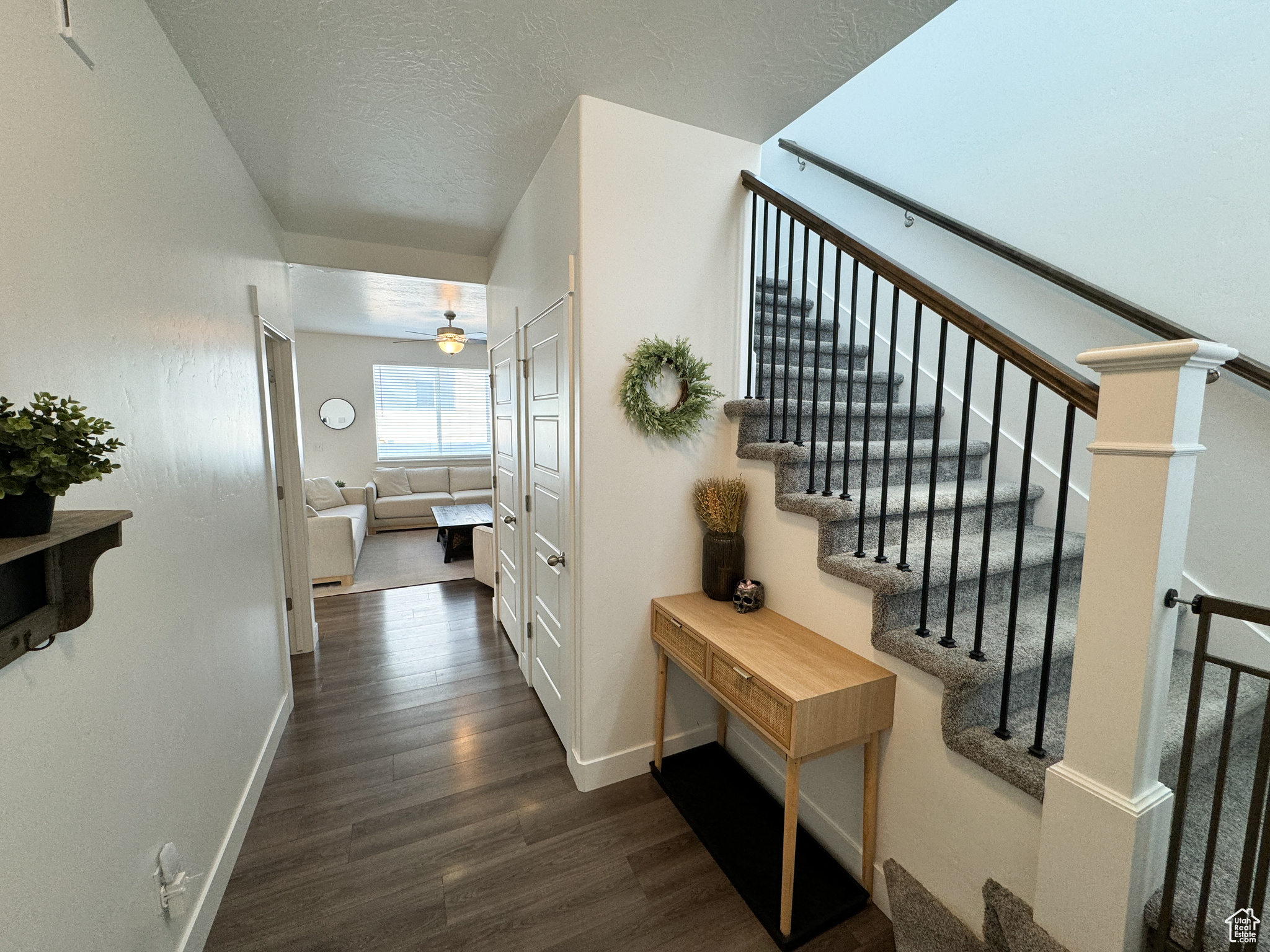 Corridor featuring a textured ceiling and dark hardwood / wood-style flooring