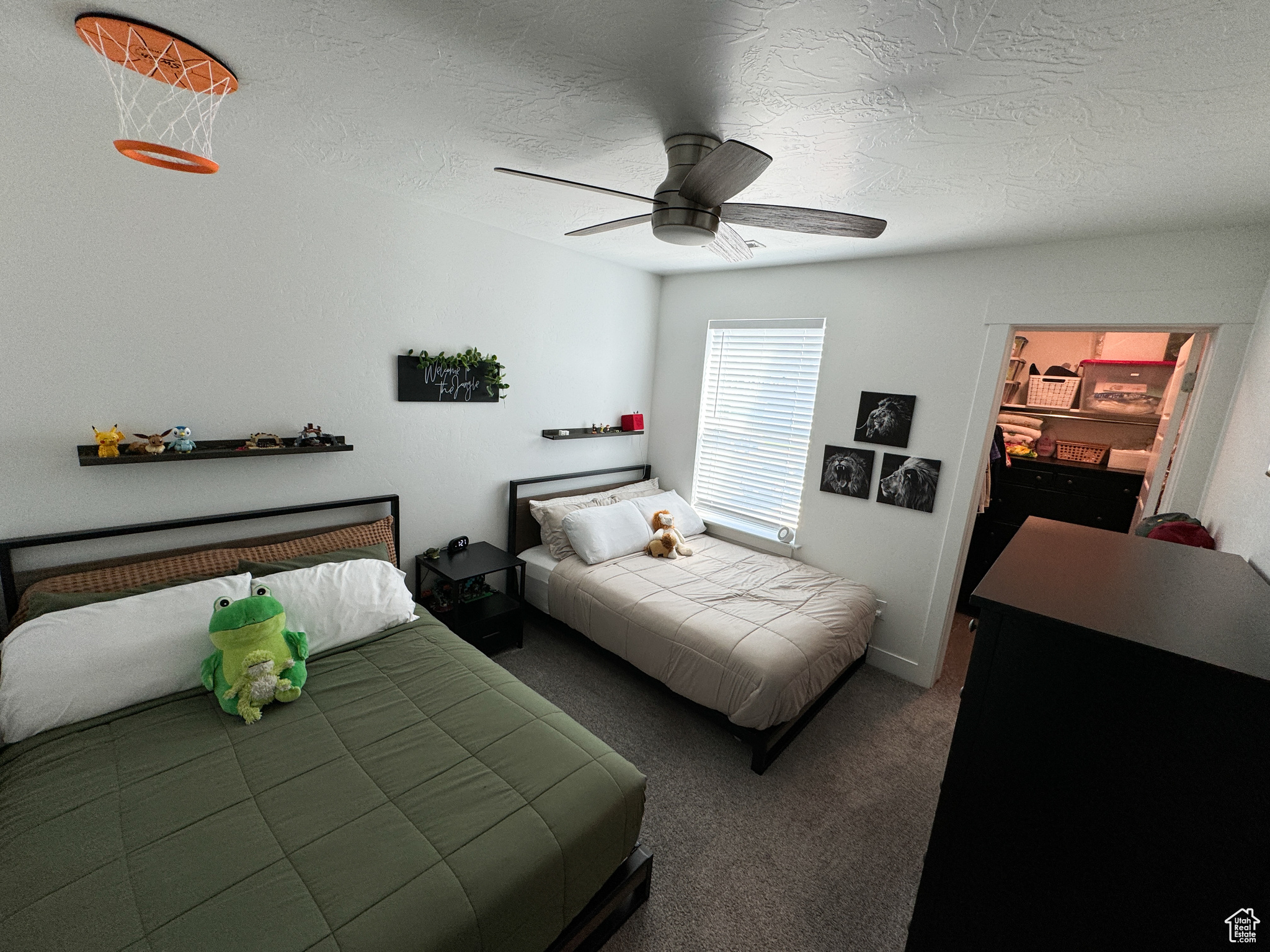 Carpeted bedroom featuring ceiling fan and a textured ceiling